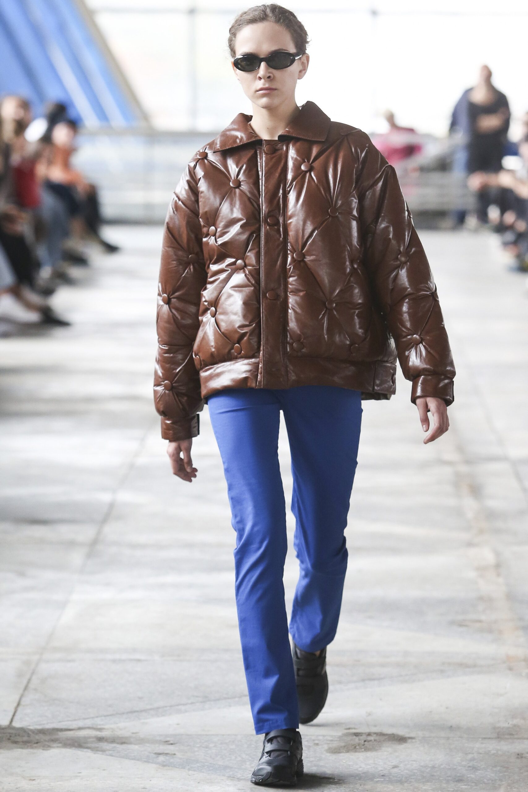 brown padded jacket with blue pants