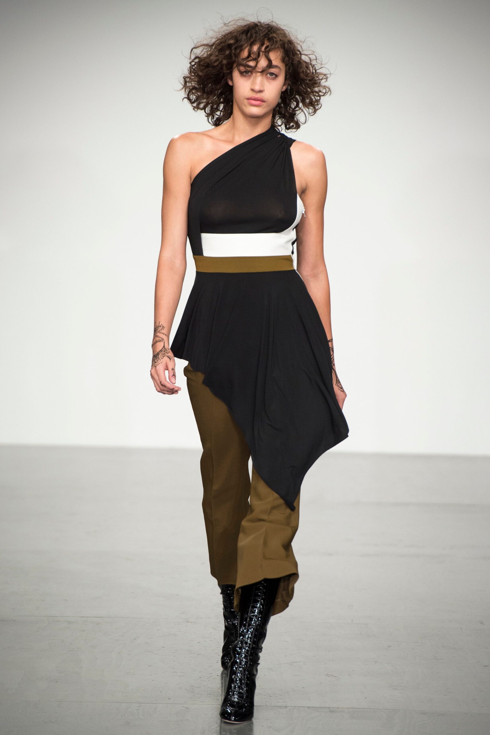 black and white asymmetric top with brown pants