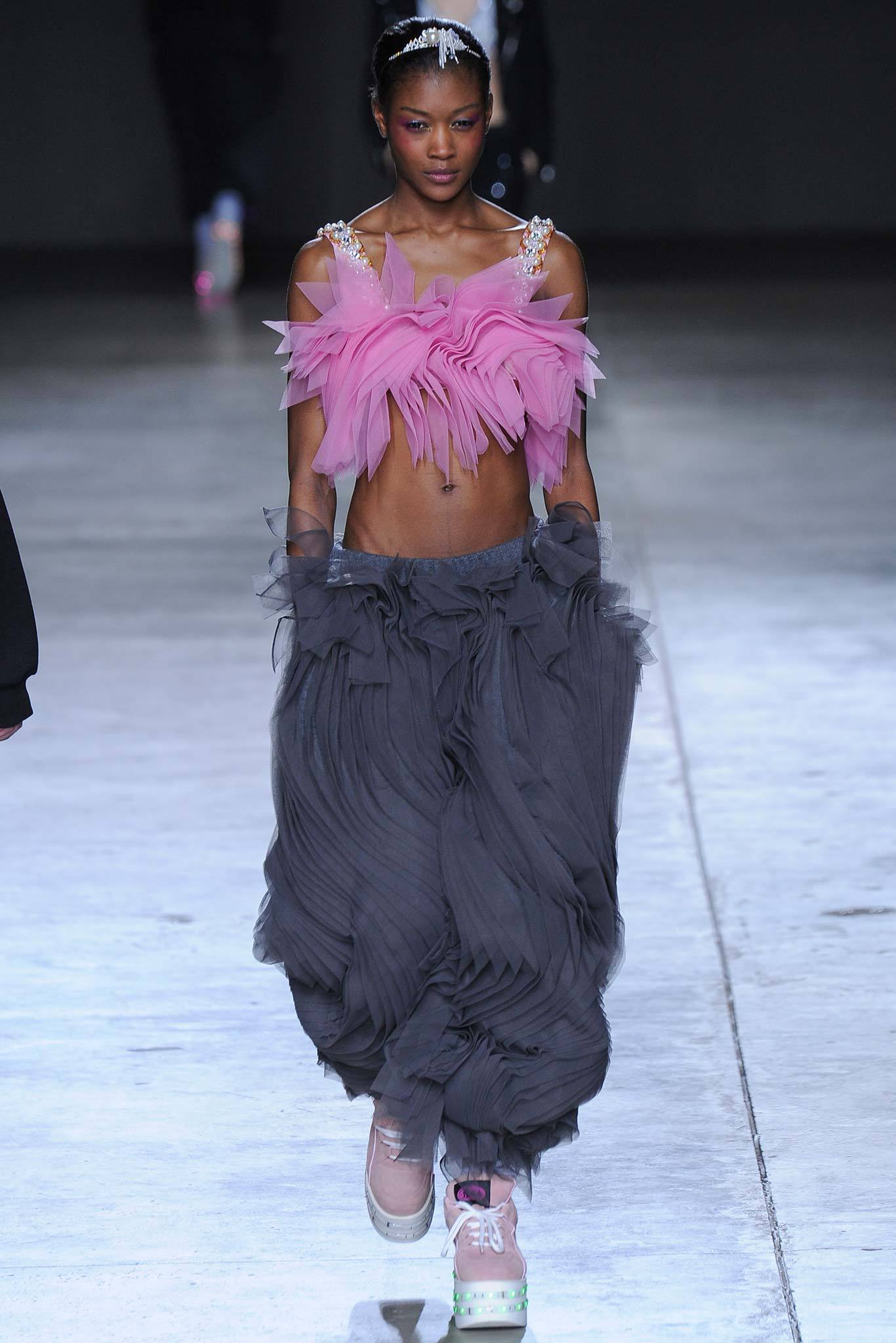 pink ruffled top with gray pants