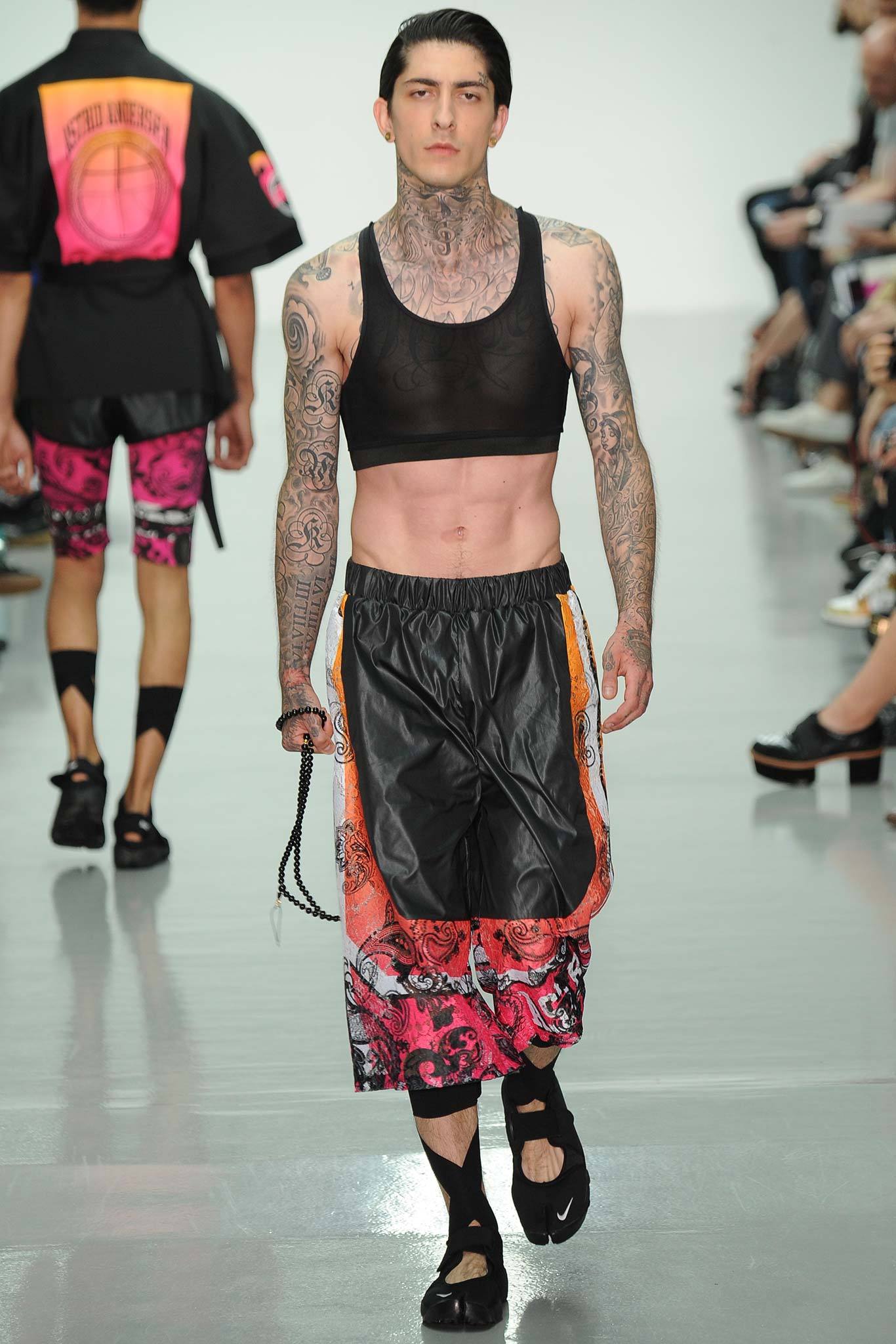 black mesh sleeveless top and orange flared pants
