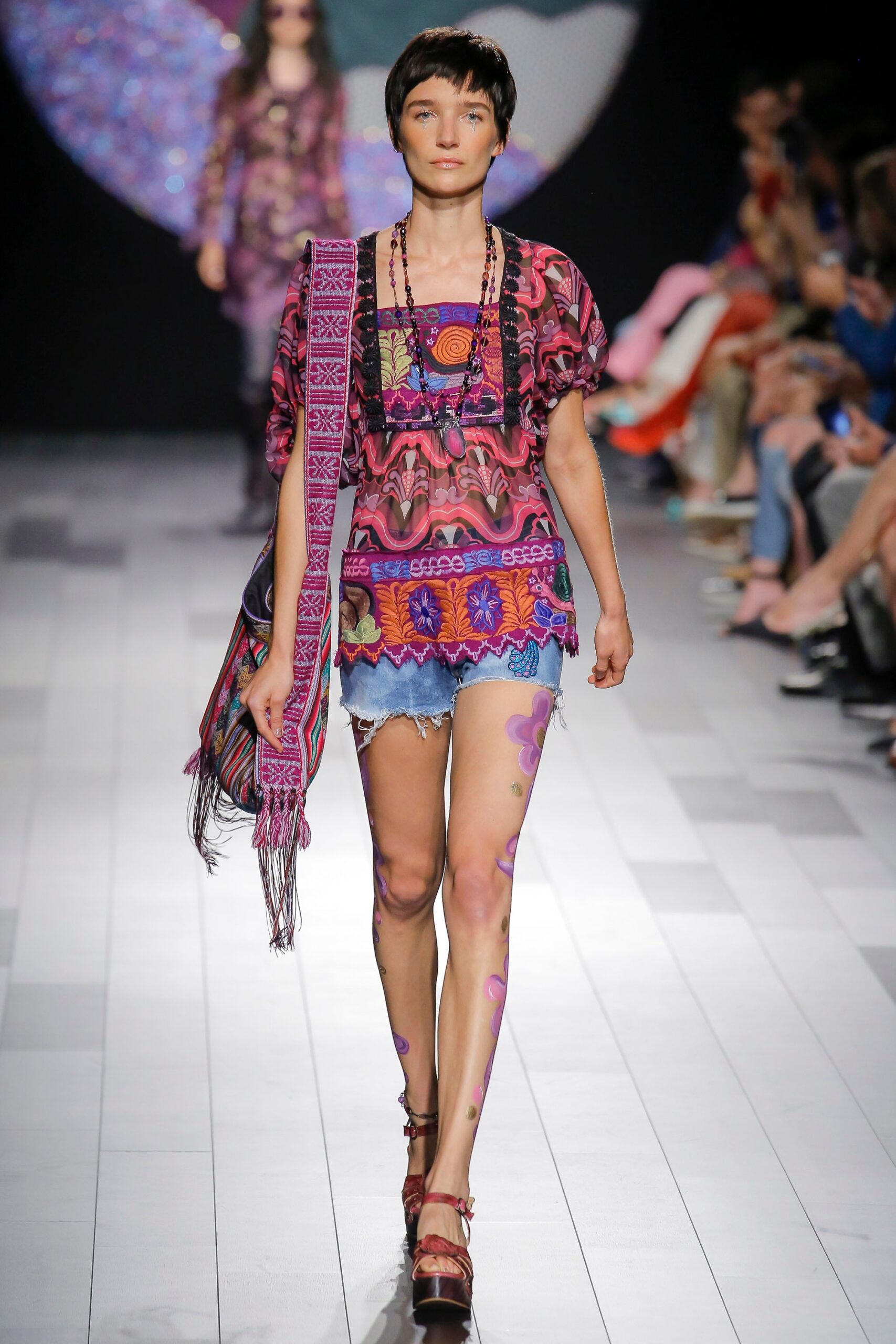 multi-colored embroidered top with denim shorts