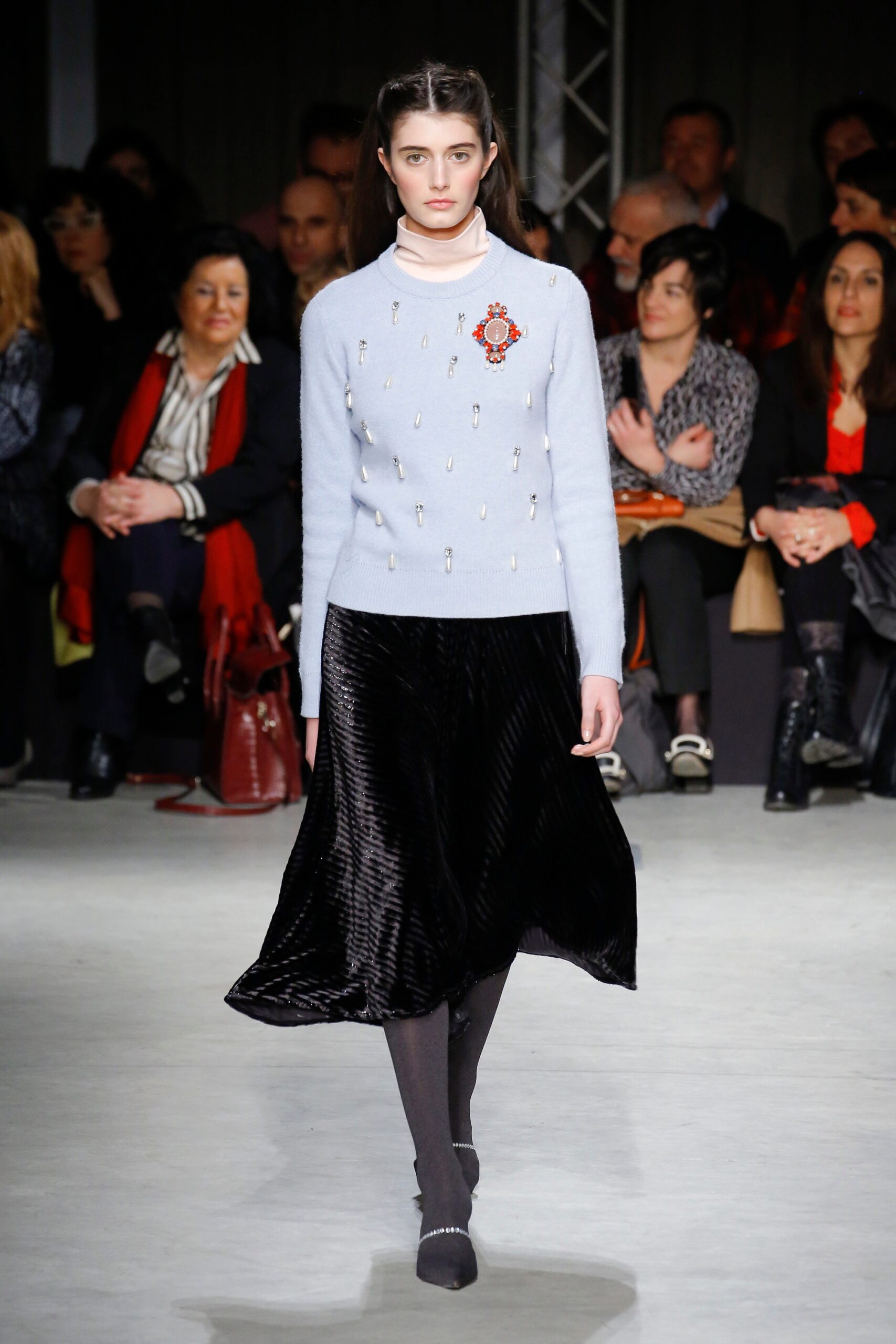 blue wool sweater with black pleated skirt