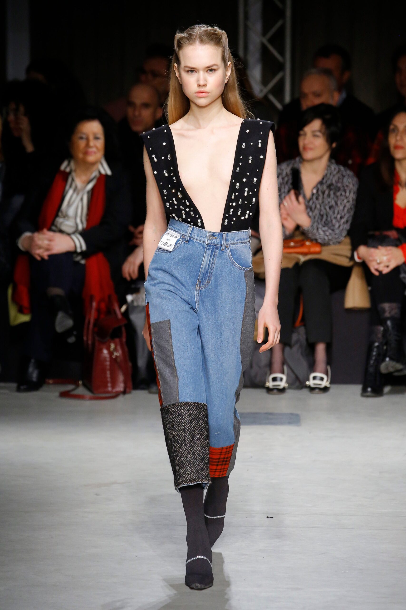 black embroidered sleeveless top and blue patchwork pants