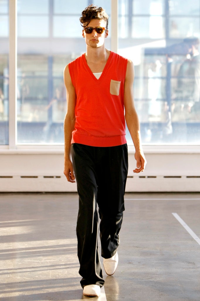 red sleeveless sweater and black pants