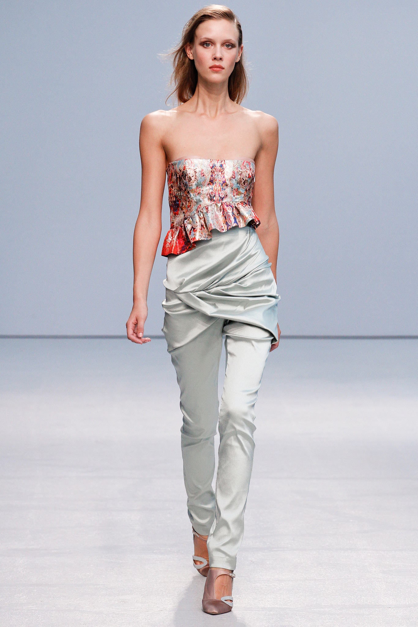 multi-colored ruffled top with gray pants