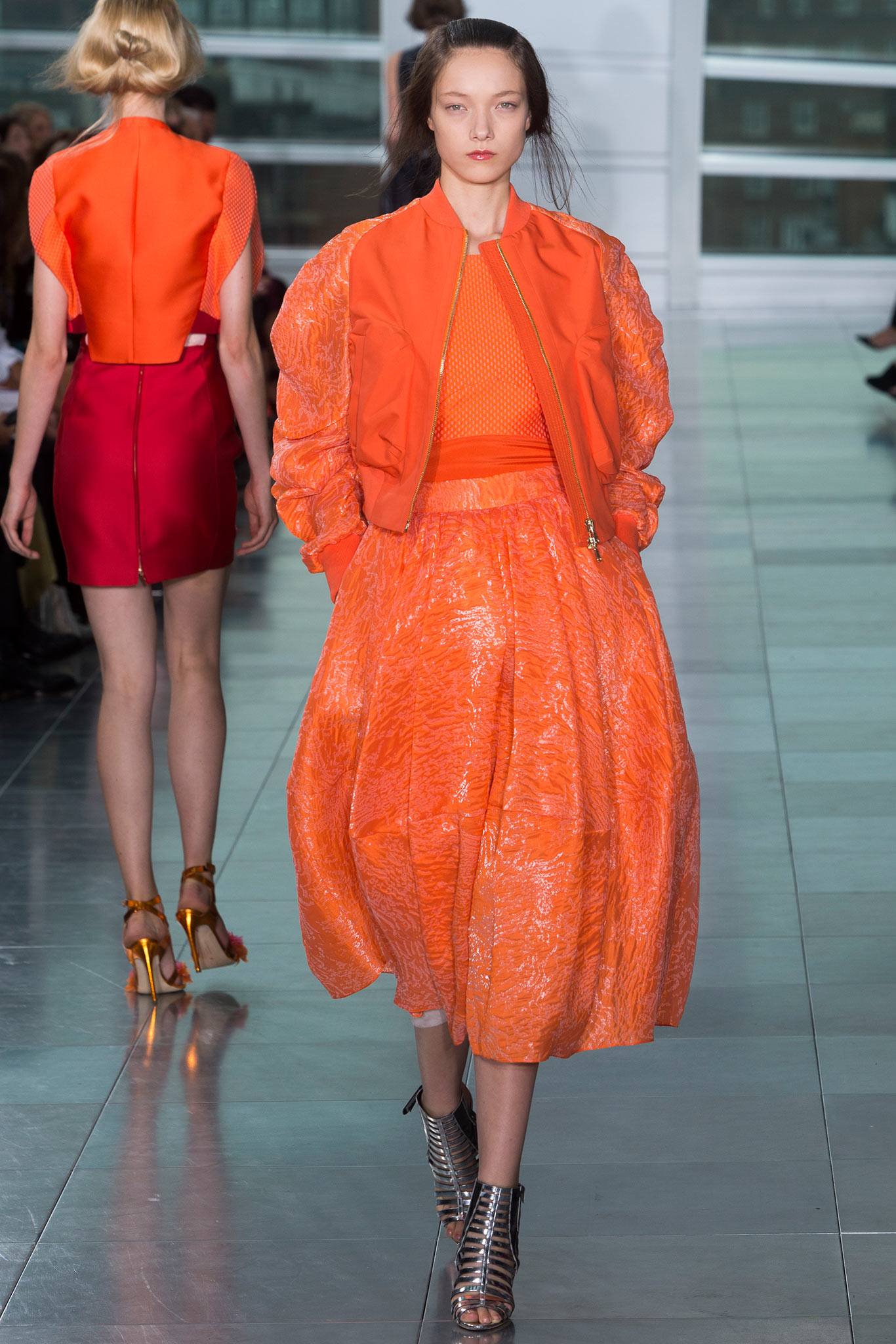 orange fitted jacket and pleated skirt