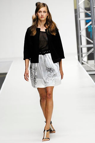 black fitted jacket with sheer top and pleated skirt