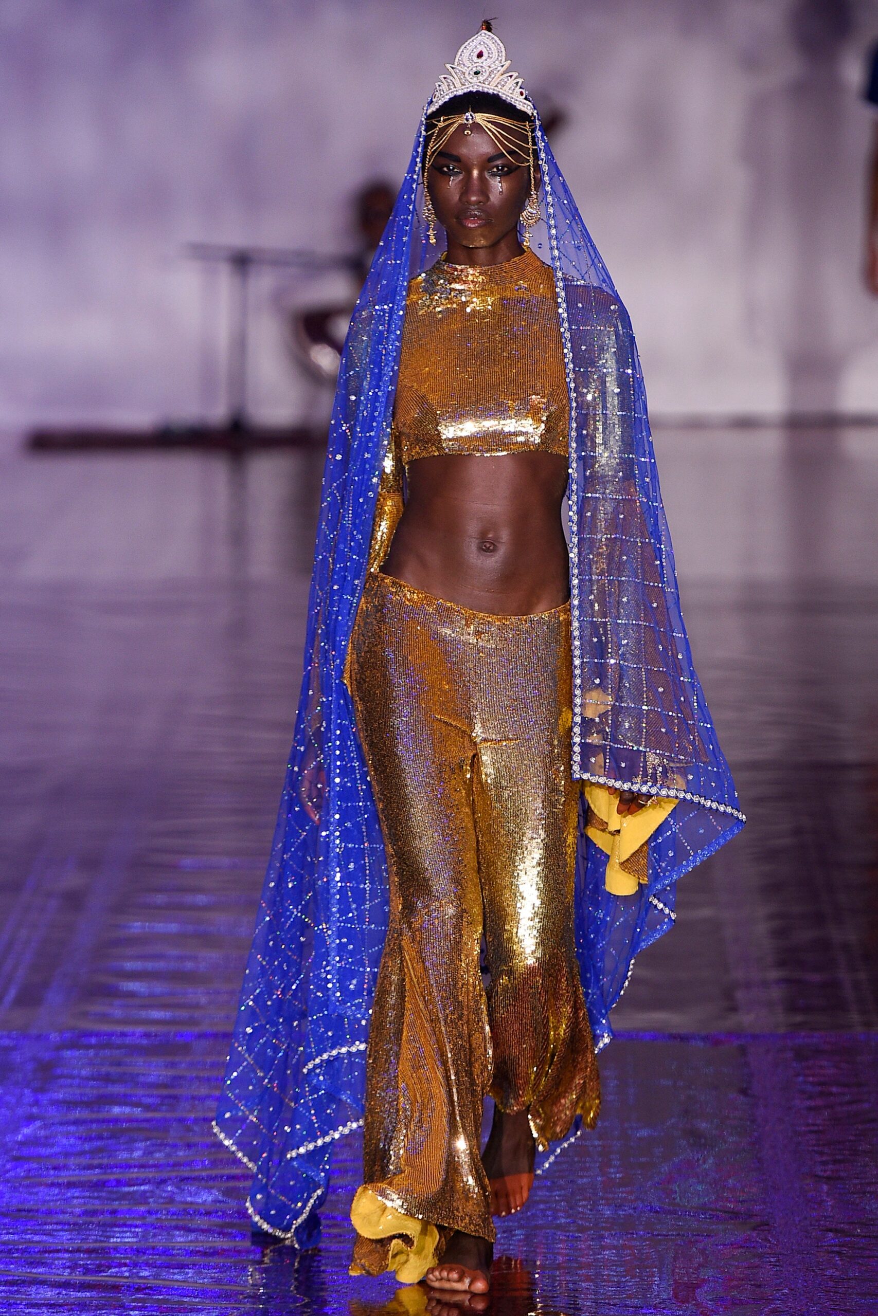 gold sequined top and pants with blue cape
