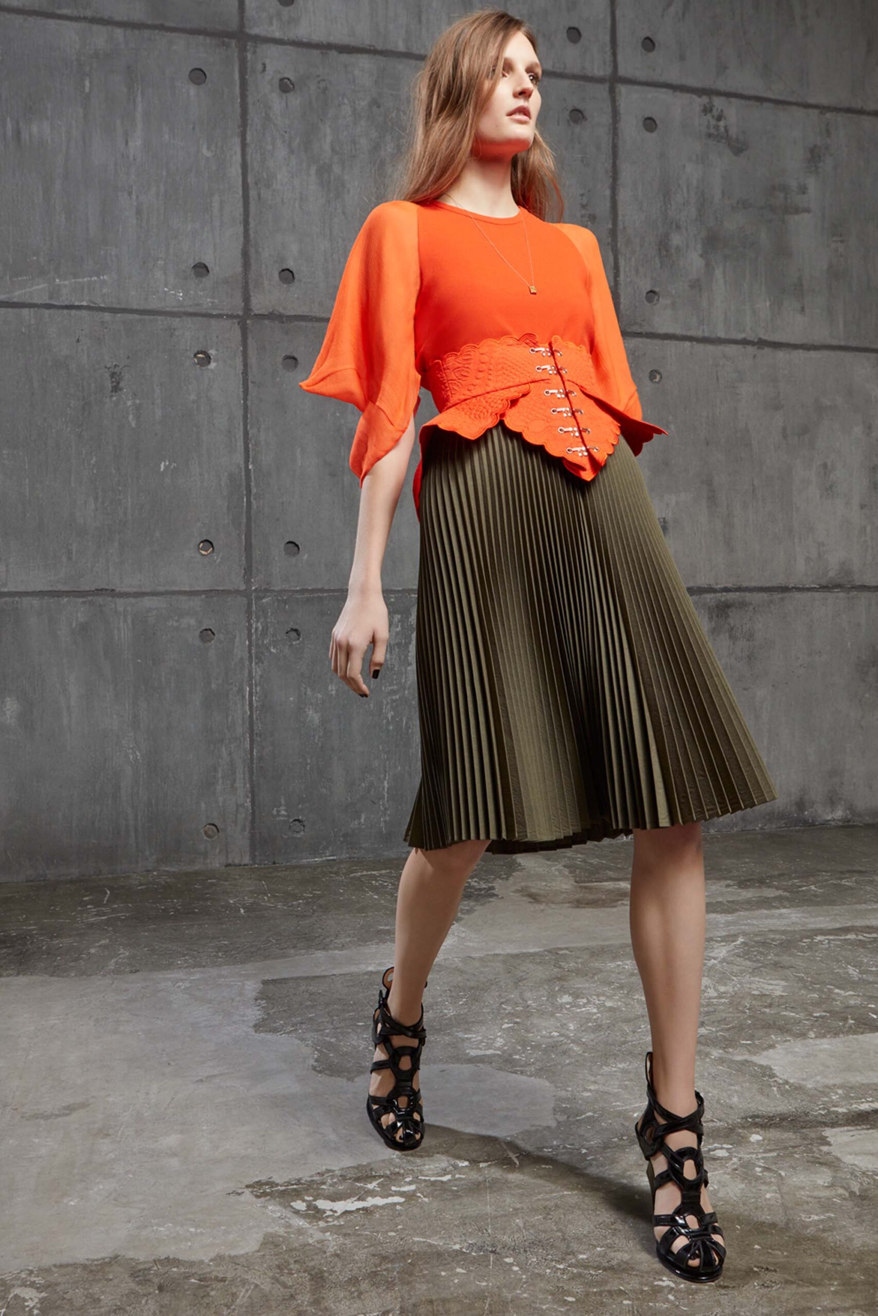 orange fitted top with pleated green skirt