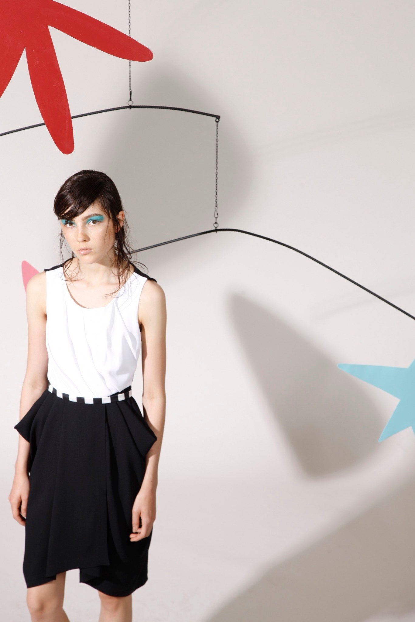 white fitted sleeveless top and black pleated skirt