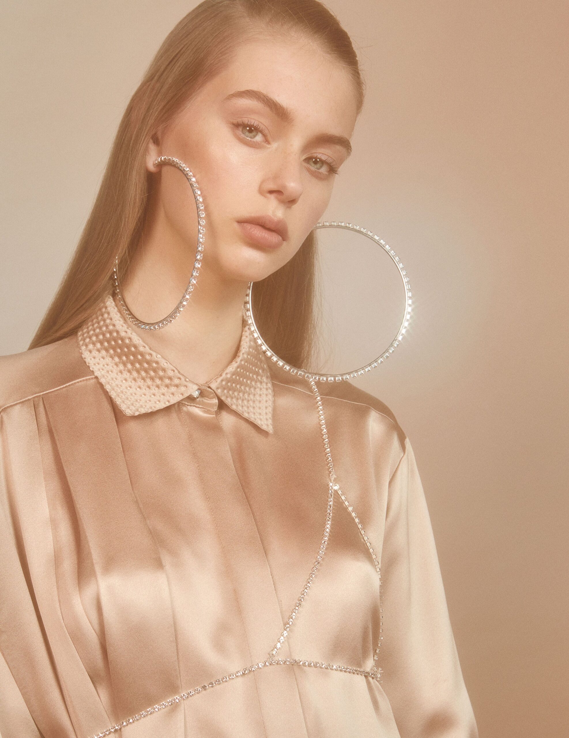 beige silk relaxed blouse with embellished earrings