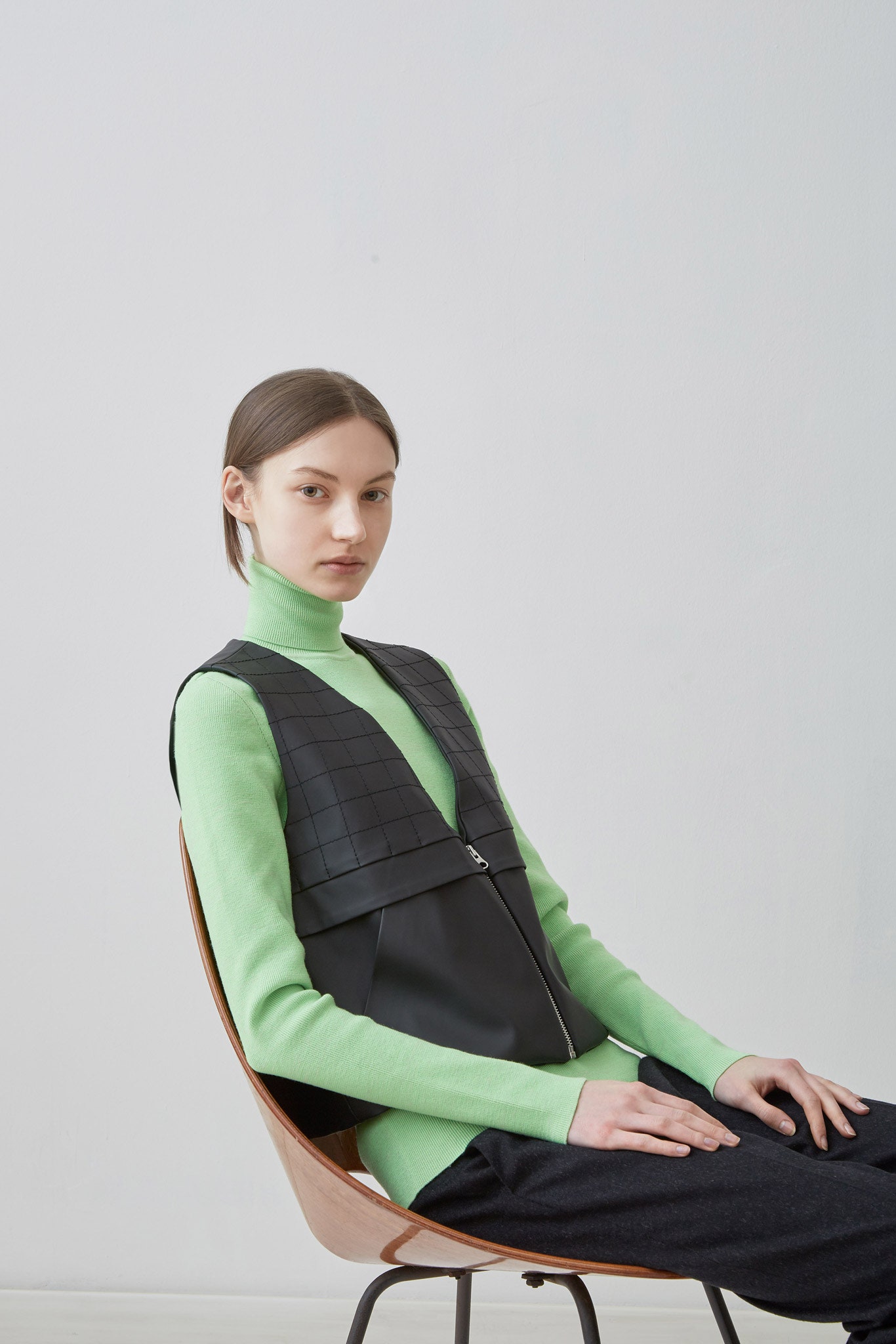 green fitted turtleneck with black vest
