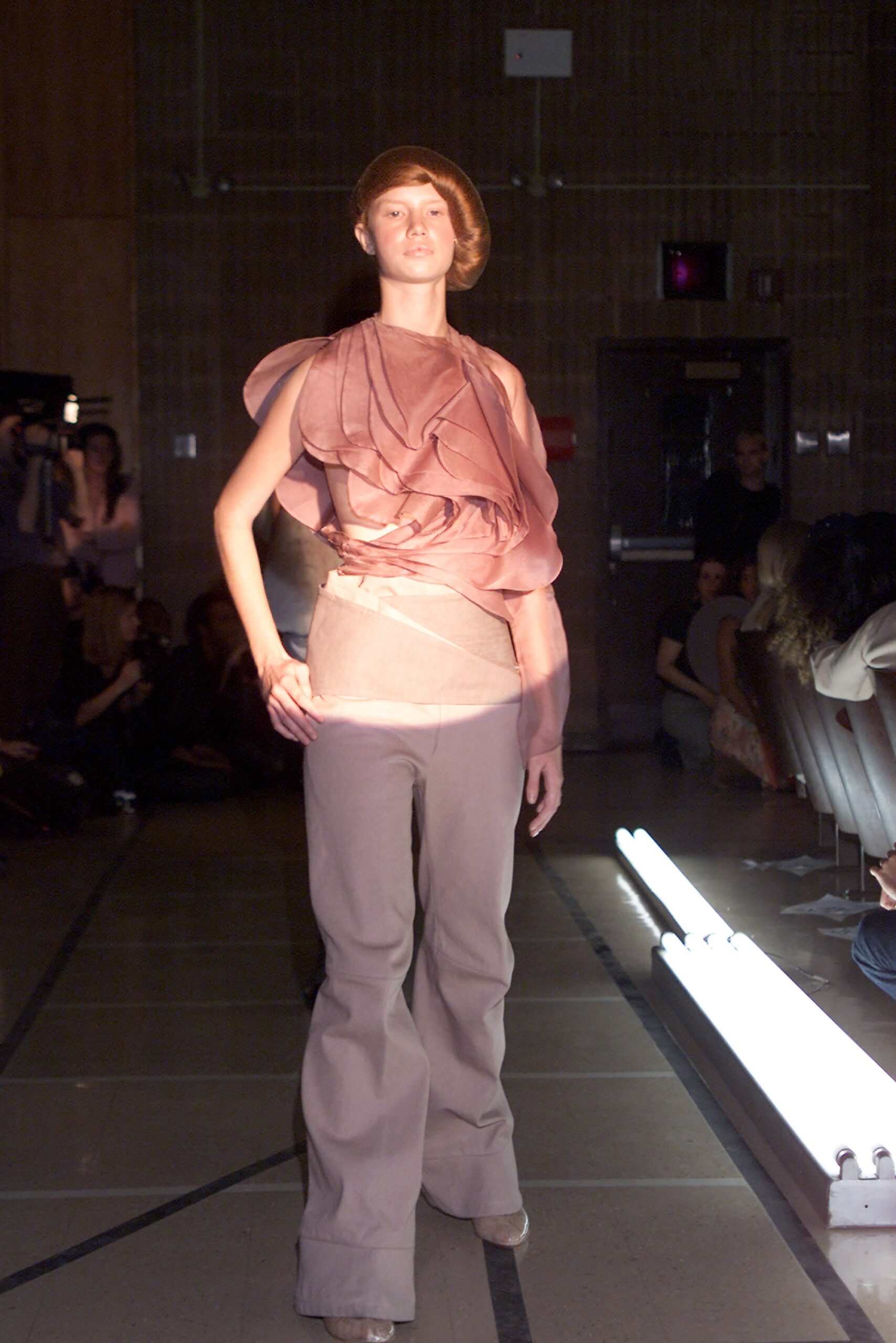 pink draped top with beige flared pants