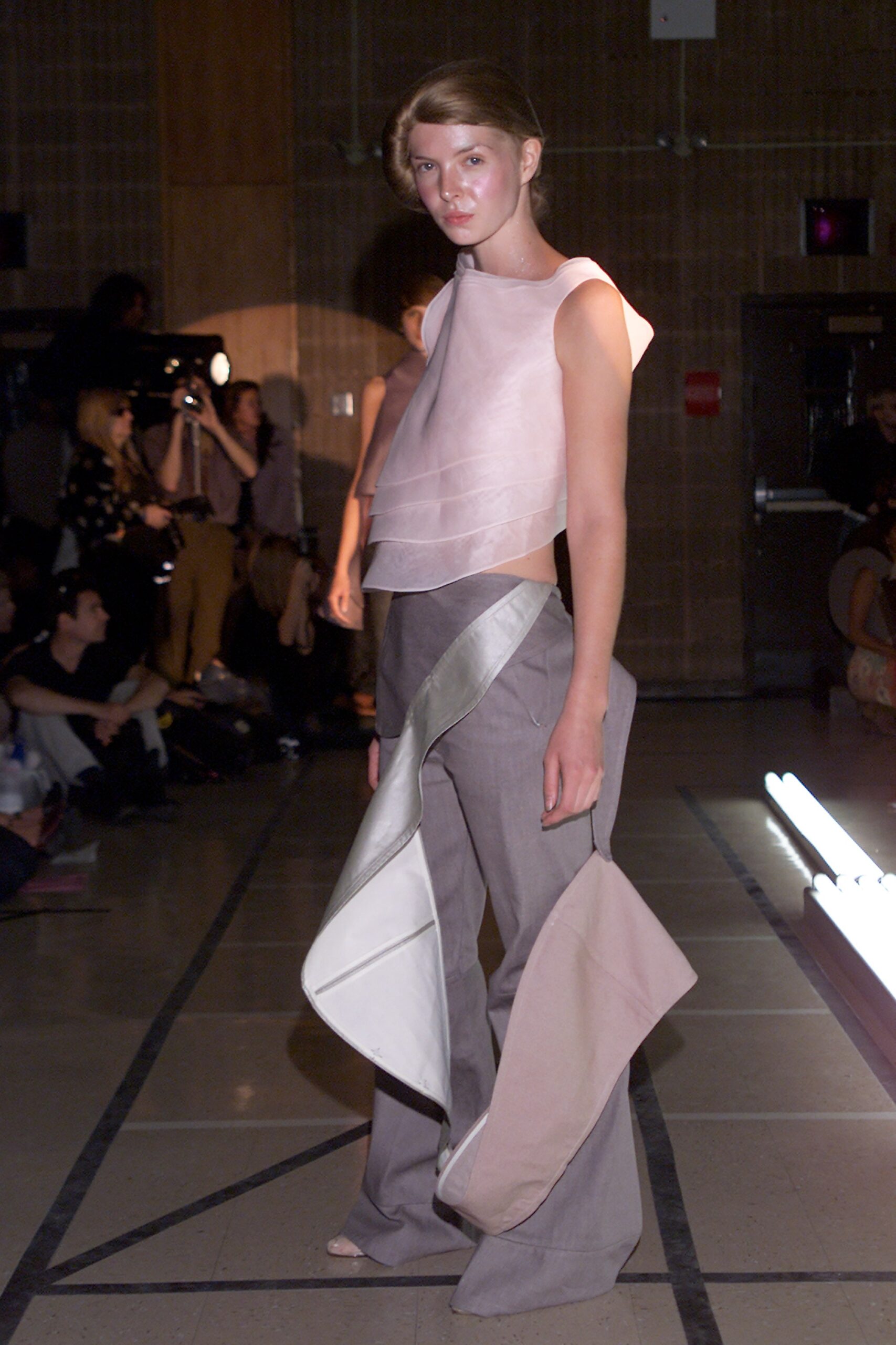 asymmetric pink silk top with gray pants