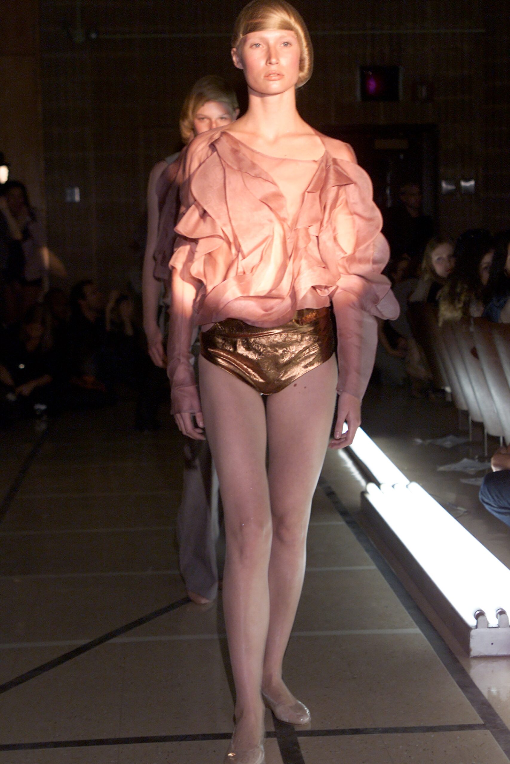 pink ruffled top with gold shorts