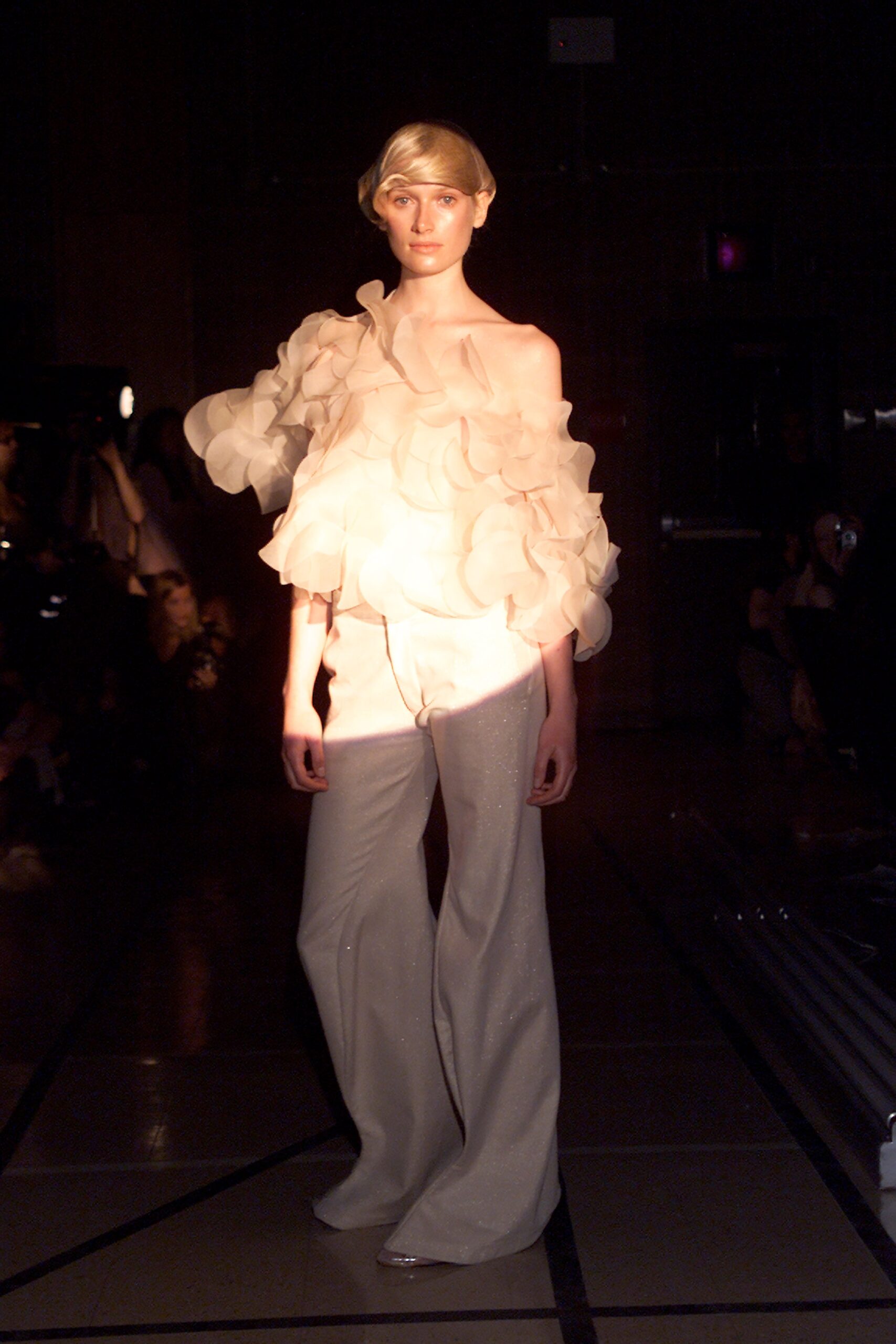 beige ruffled top and white flared pants