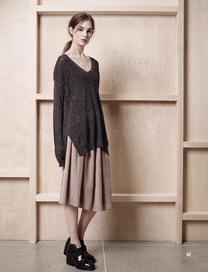 relaxed black sweater and beige pleated skirt