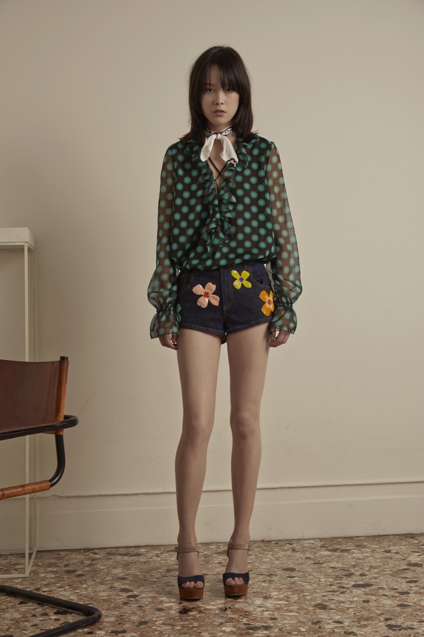 green polka-dot blouse with denim shorts