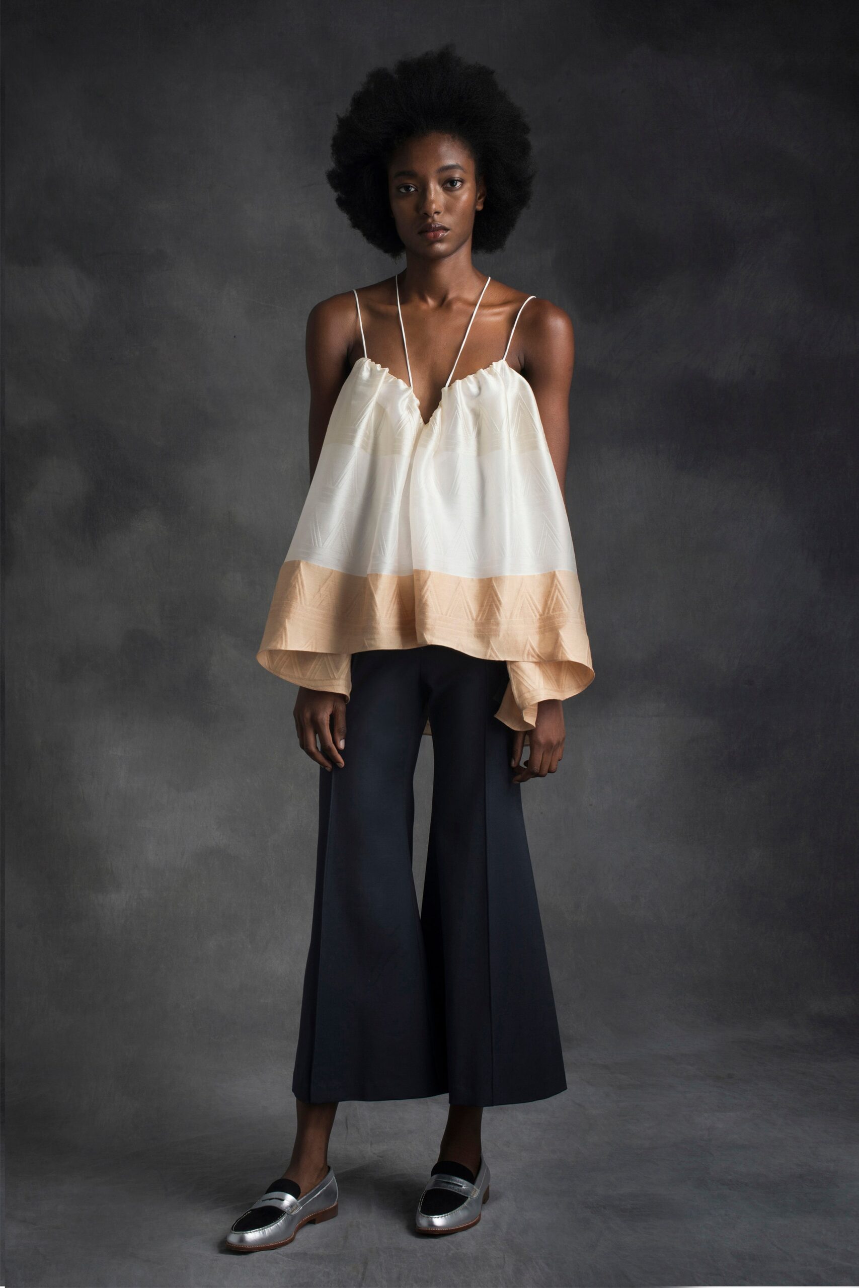 white and beige layered top with black flared pants