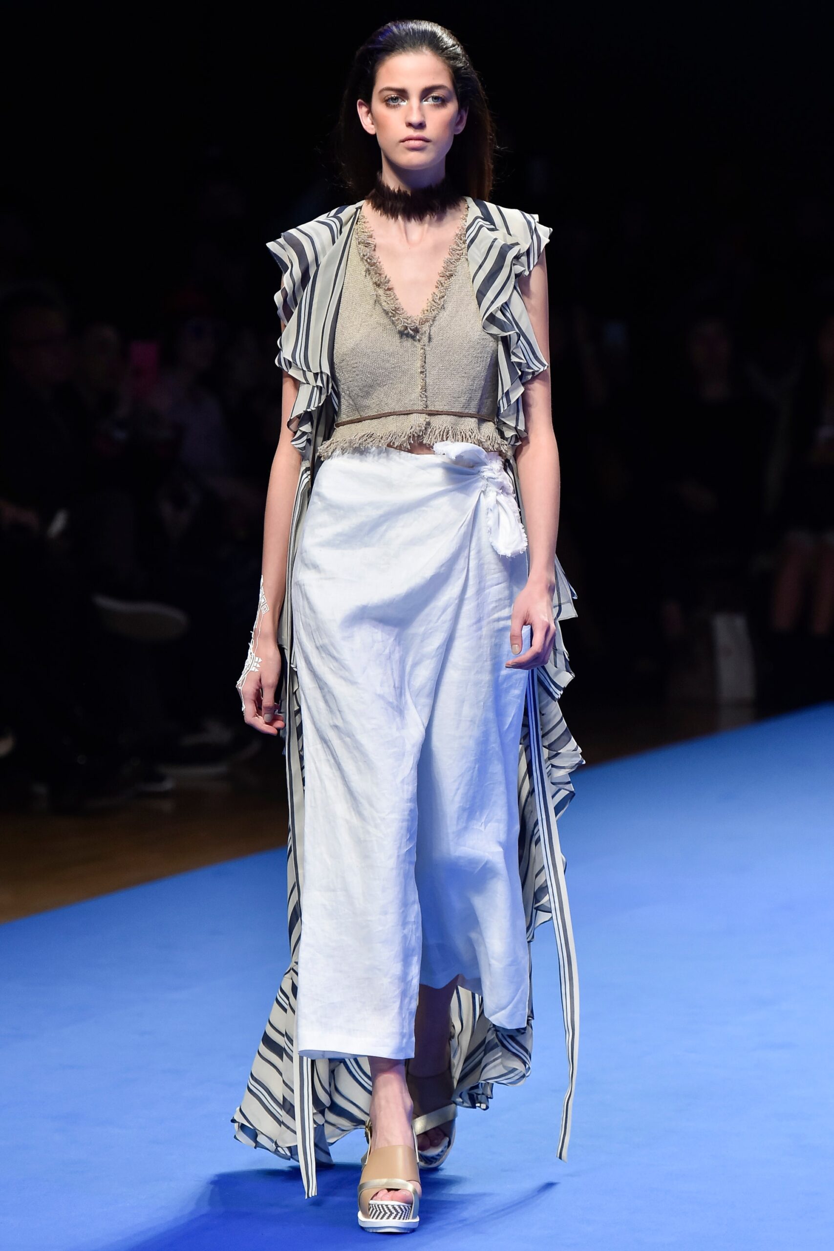 gray ruffled top and white skirt