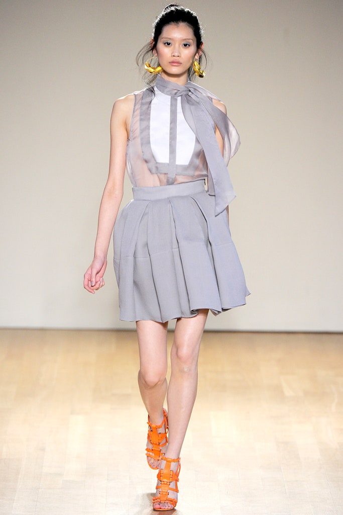 white silk sleeveless blouse and gray pleated skirt