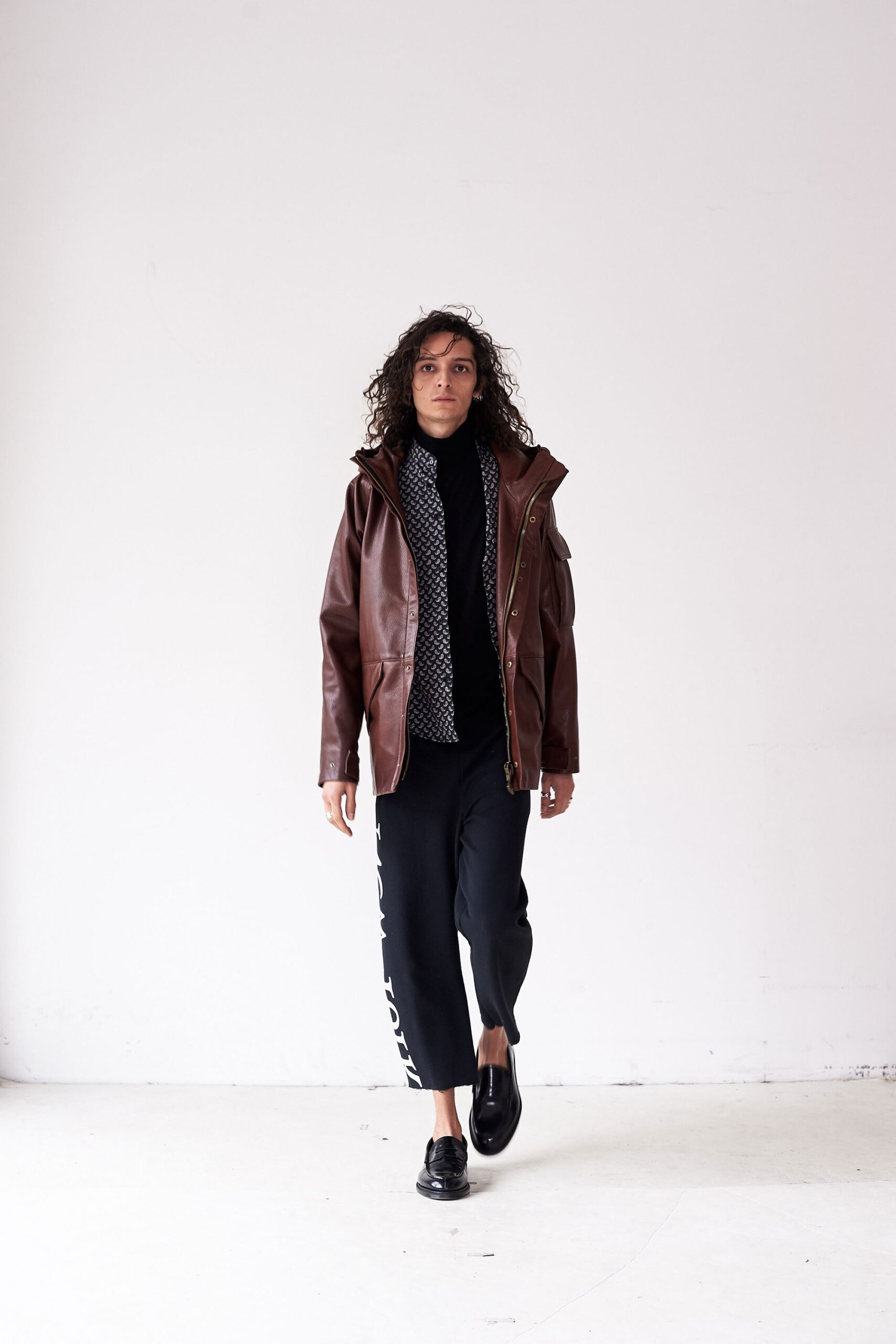 brown leather jacket with black sweater and pants