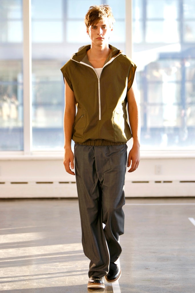 green sleeveless hoodie and gray pants