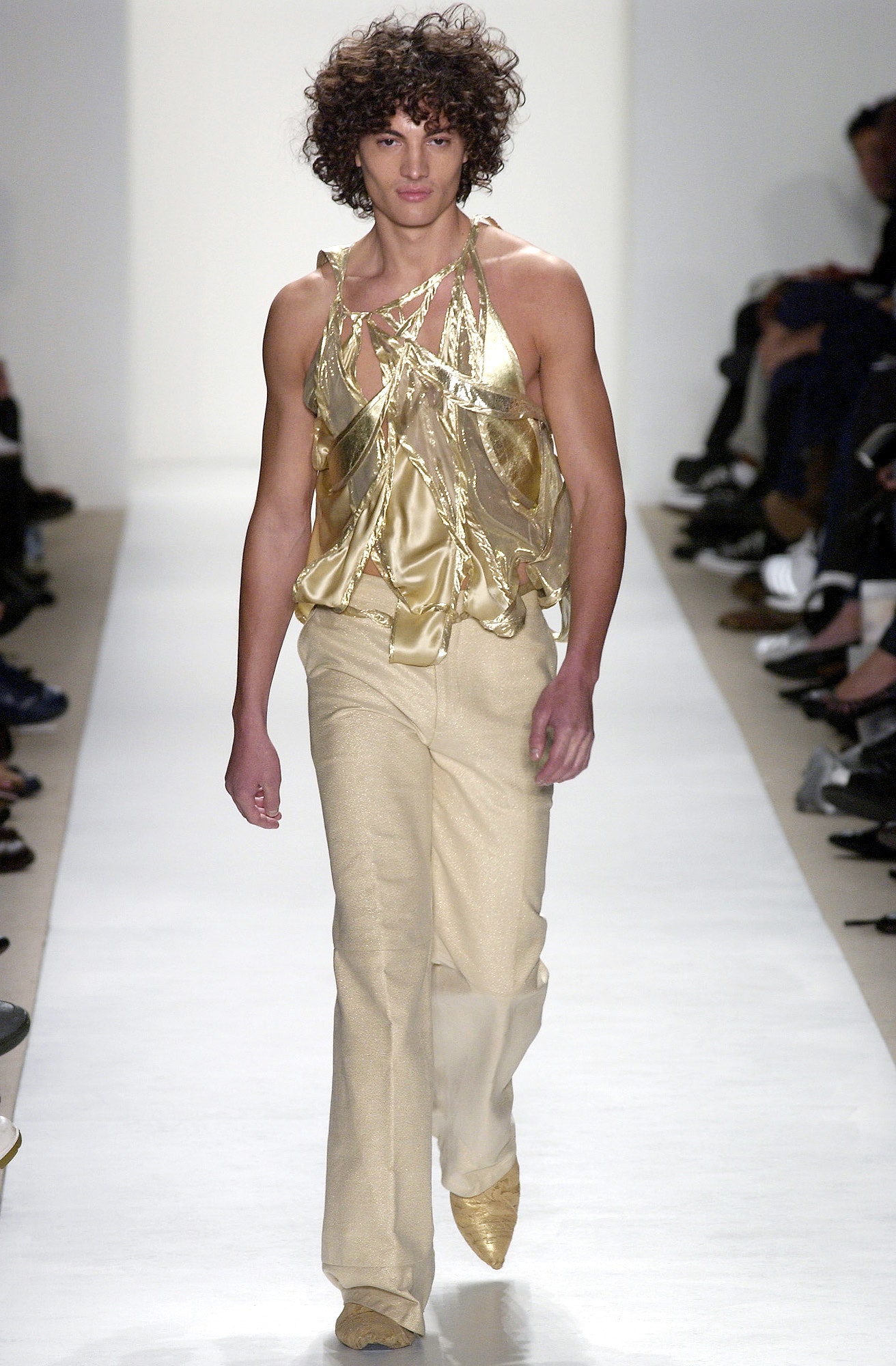 gold draped sleeveless top and beige flared pants