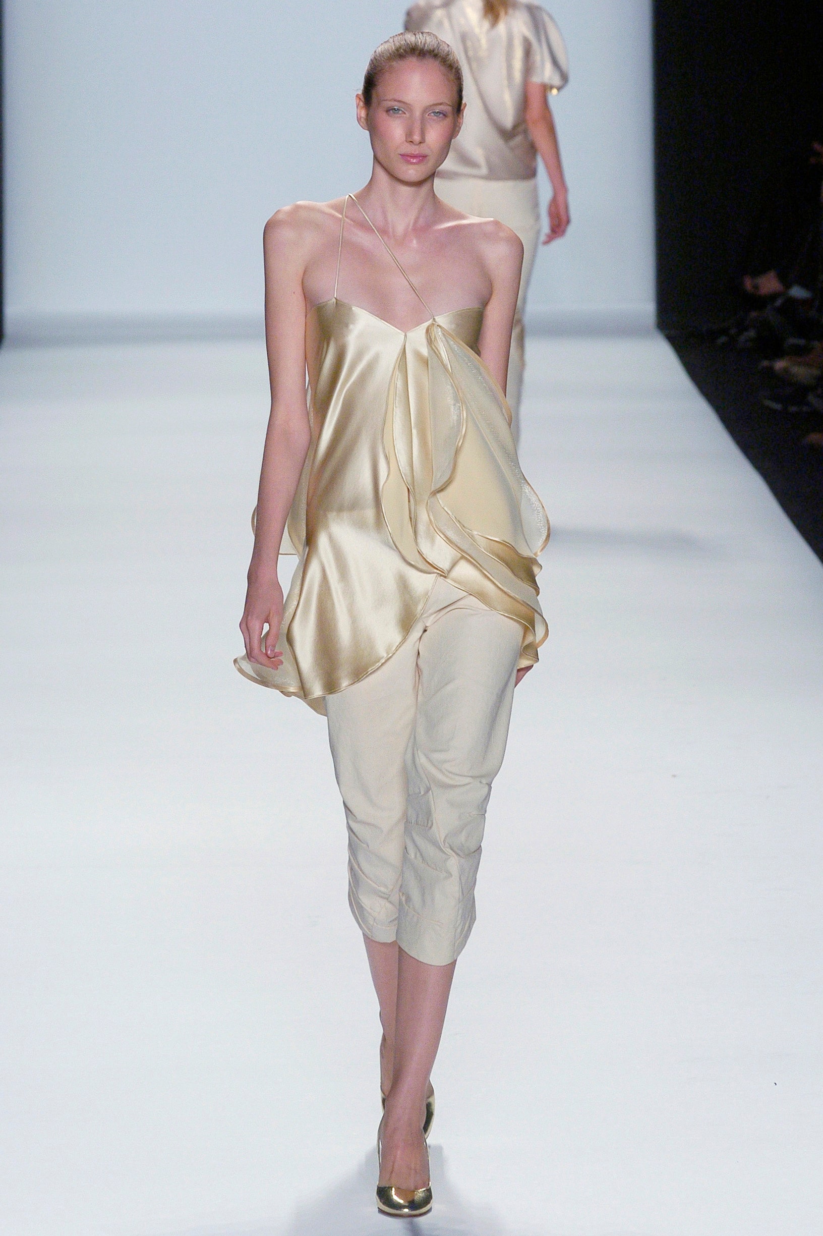 gold silk draped top with beige pants