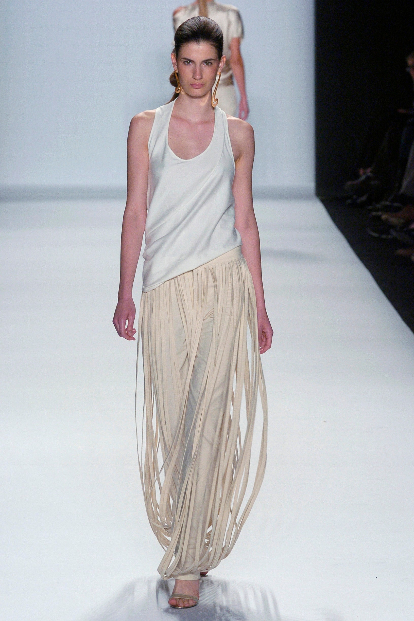 white silk sleeveless top and beige pleated pants