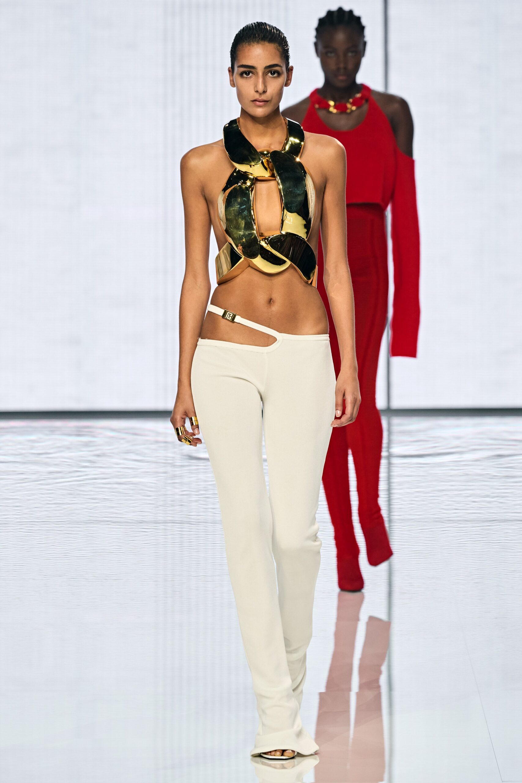 black and gold cutout top with white pants