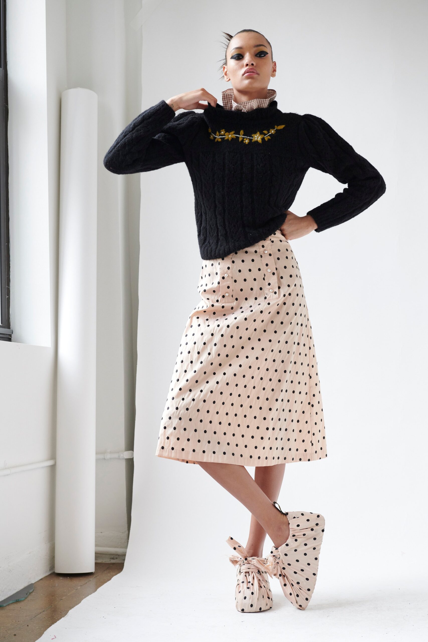 black wool turtleneck sweater and pink polka-dot skirt