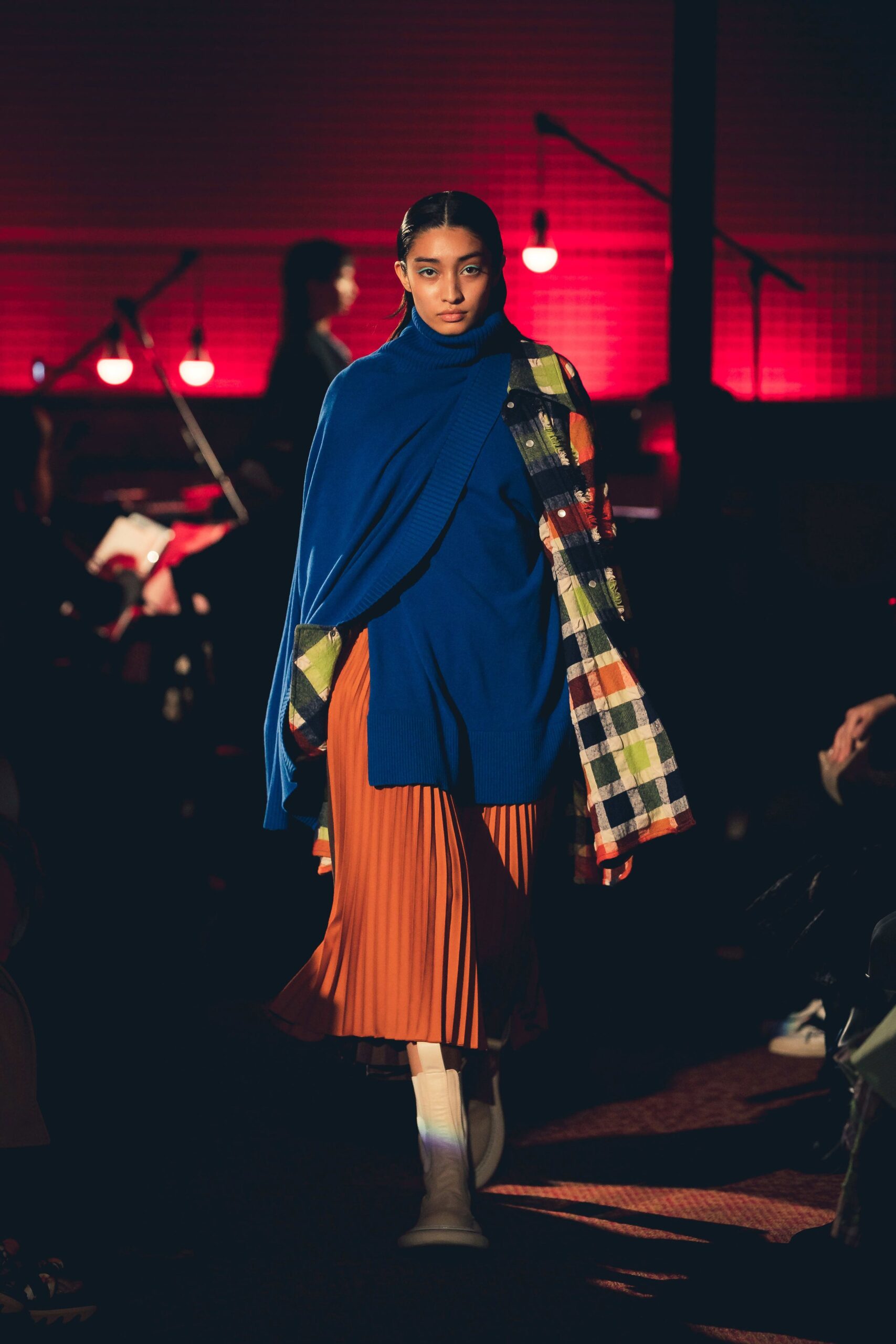 blue top and orange pleated skirt