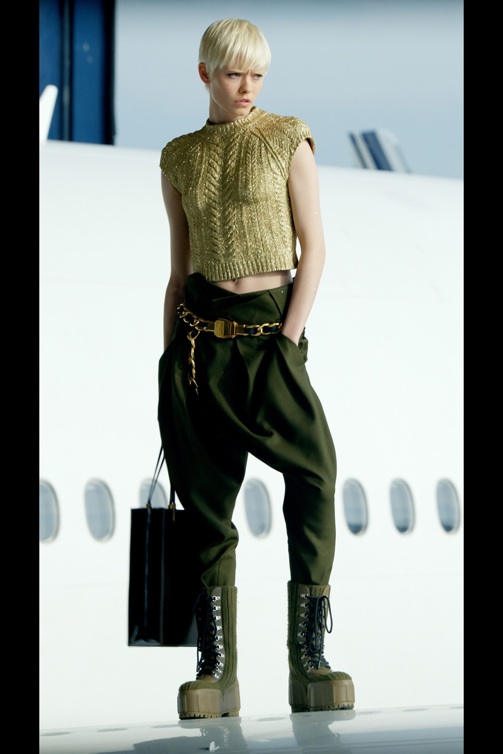 gold fitted sleeveless top with green pants