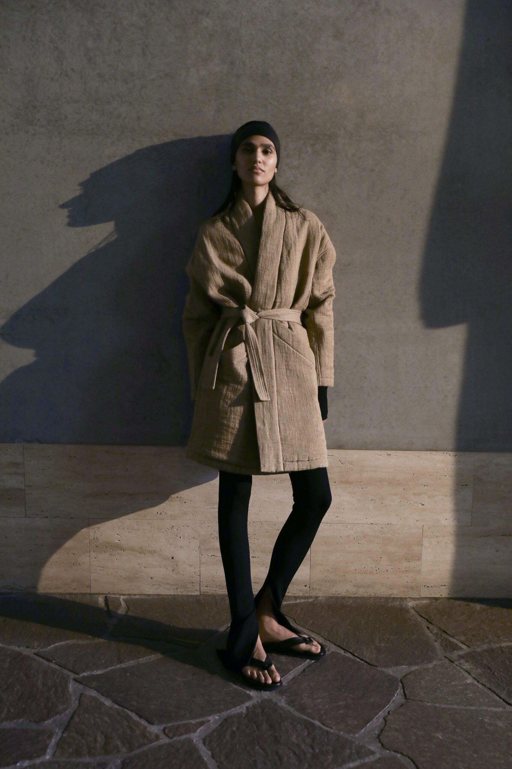 beige relaxed coat with black leggings