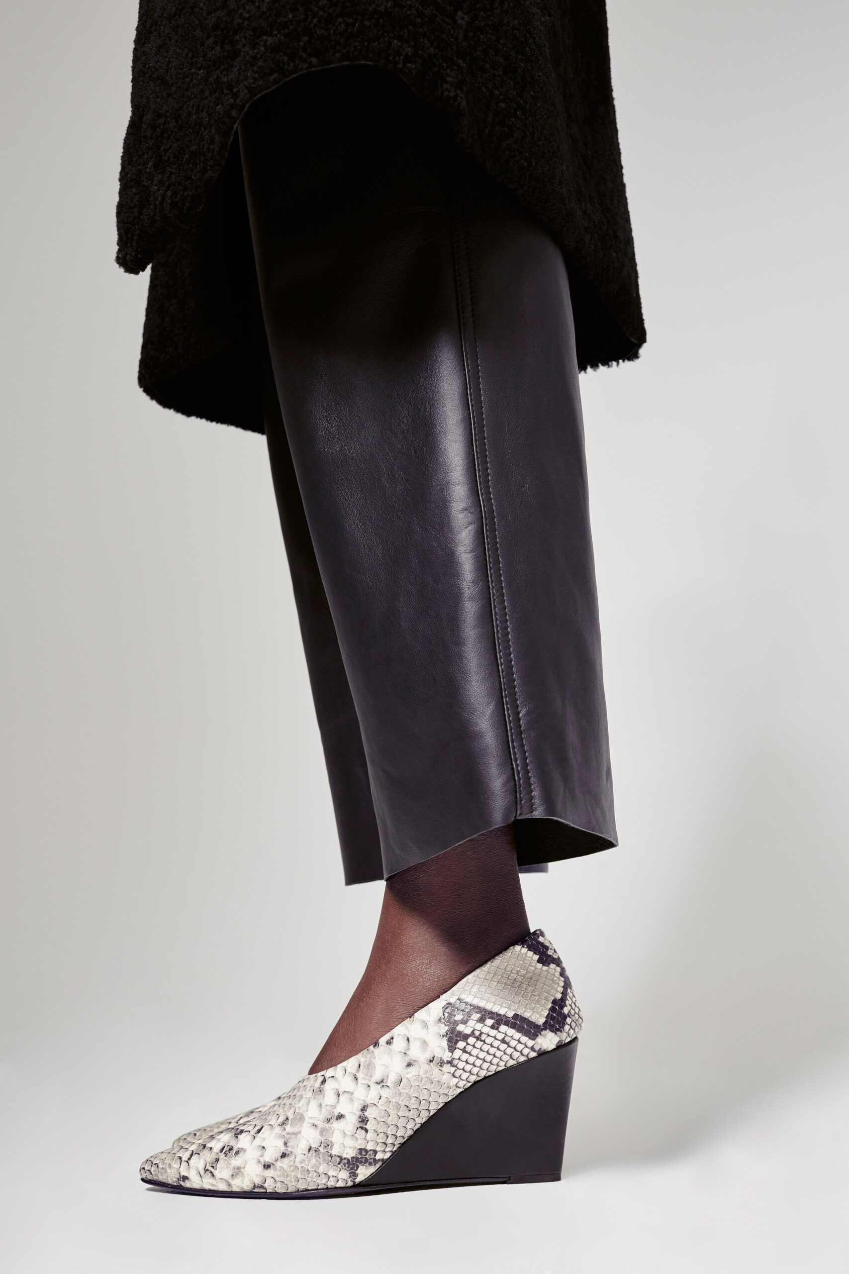 black leather fitted pants and snakeskin shoes