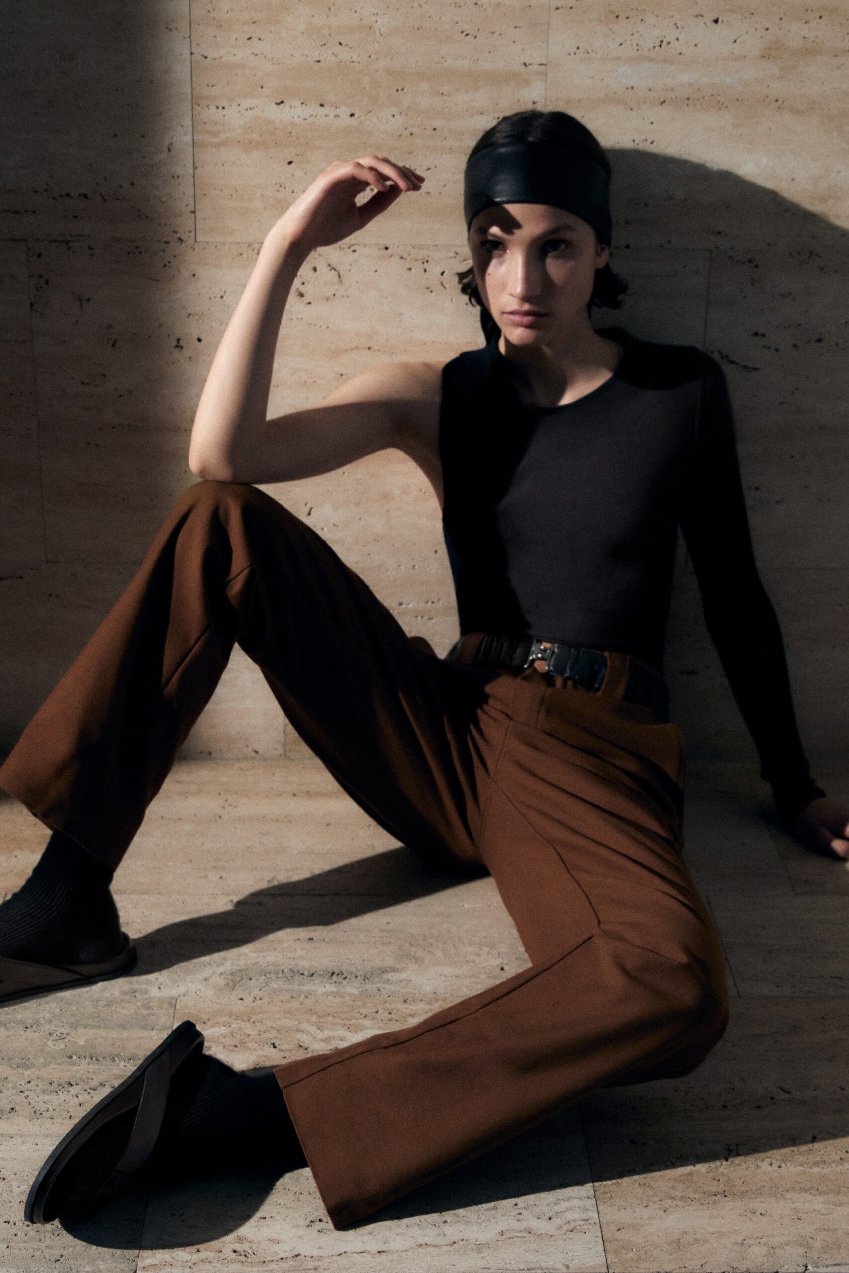 black fitted top and brown tailored pants