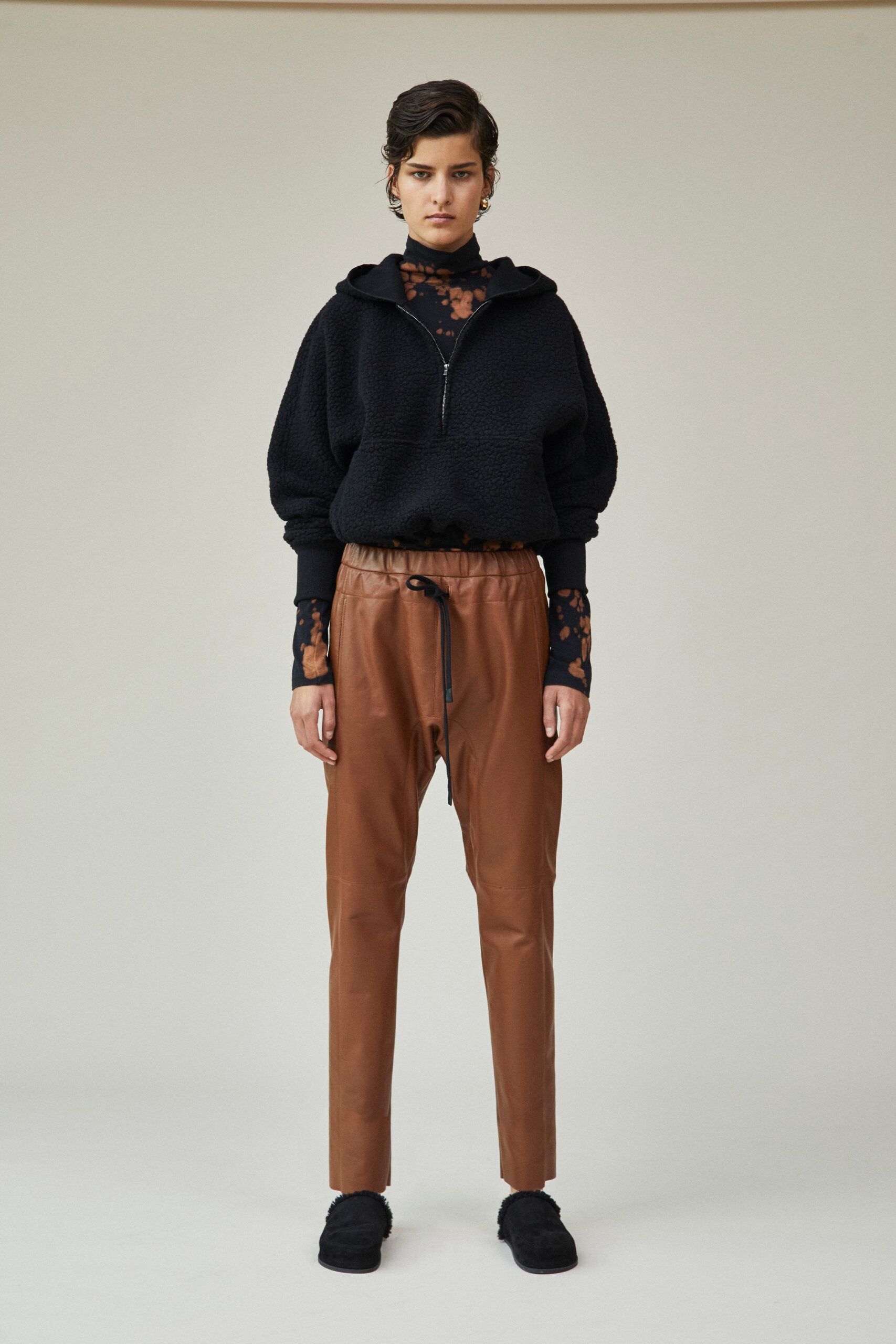 black faux-fur hoodie and brown leather pants