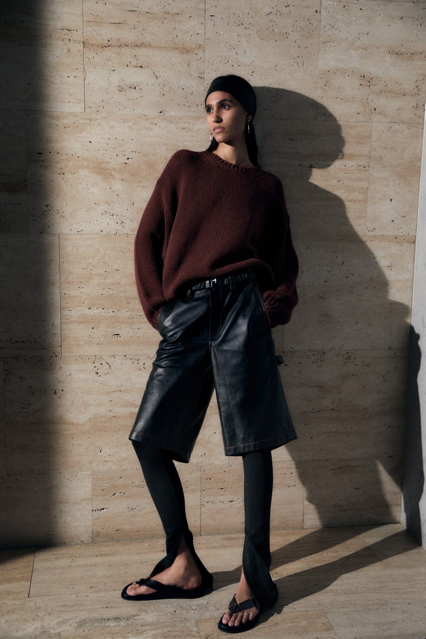 brown oversized sweater with black leather shorts