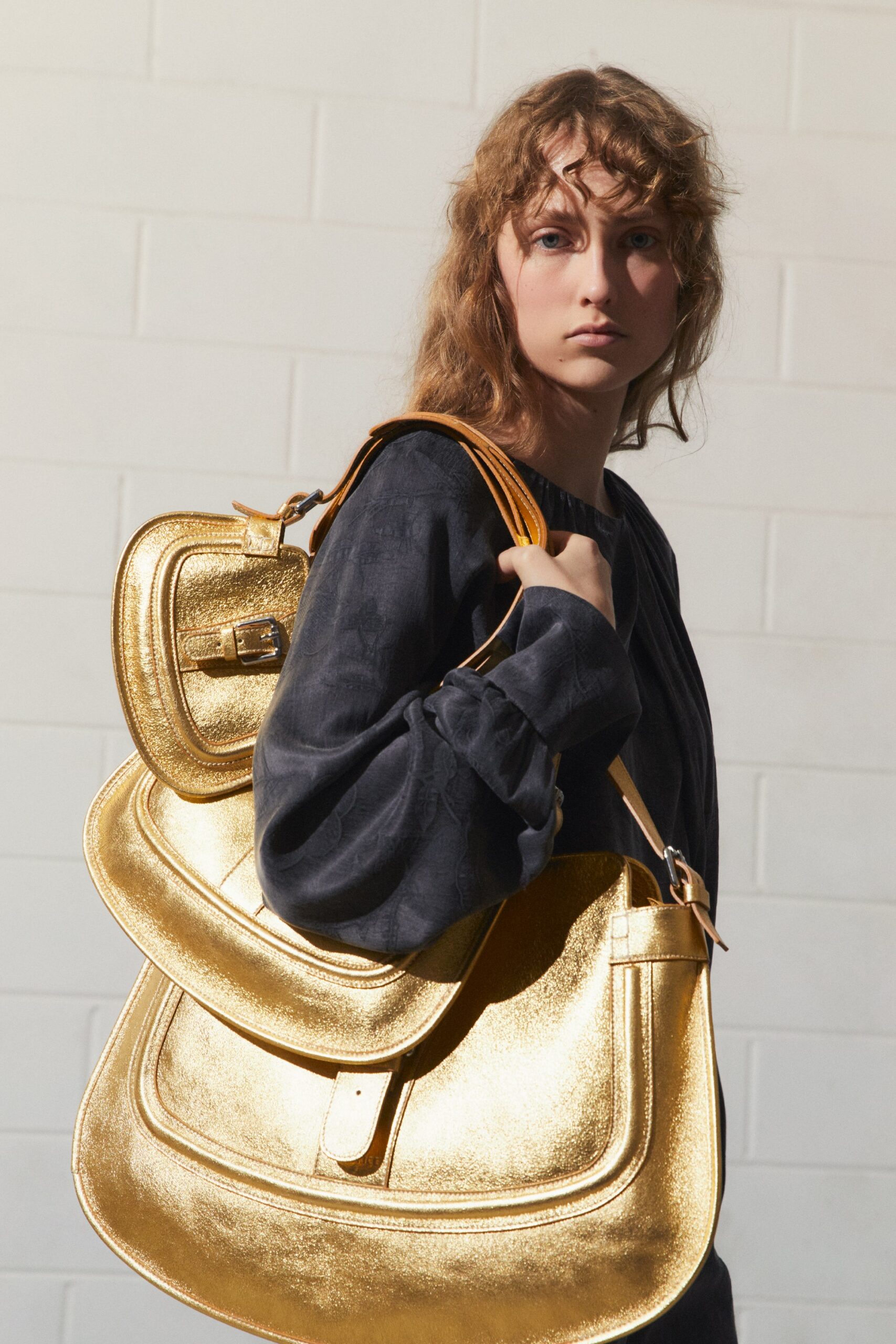 black relaxed top with gold bag