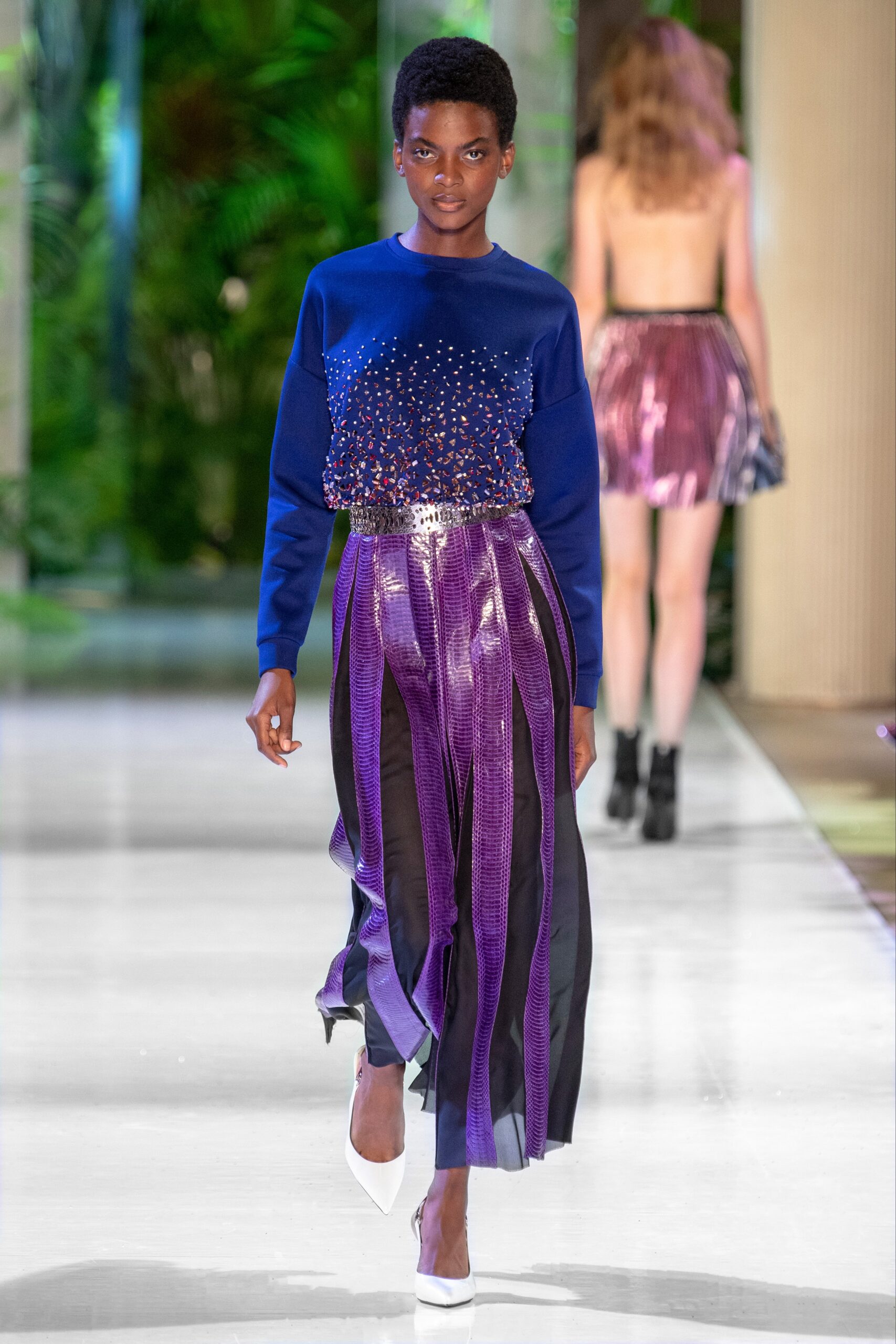 blue embellished top and purple pleated skirt