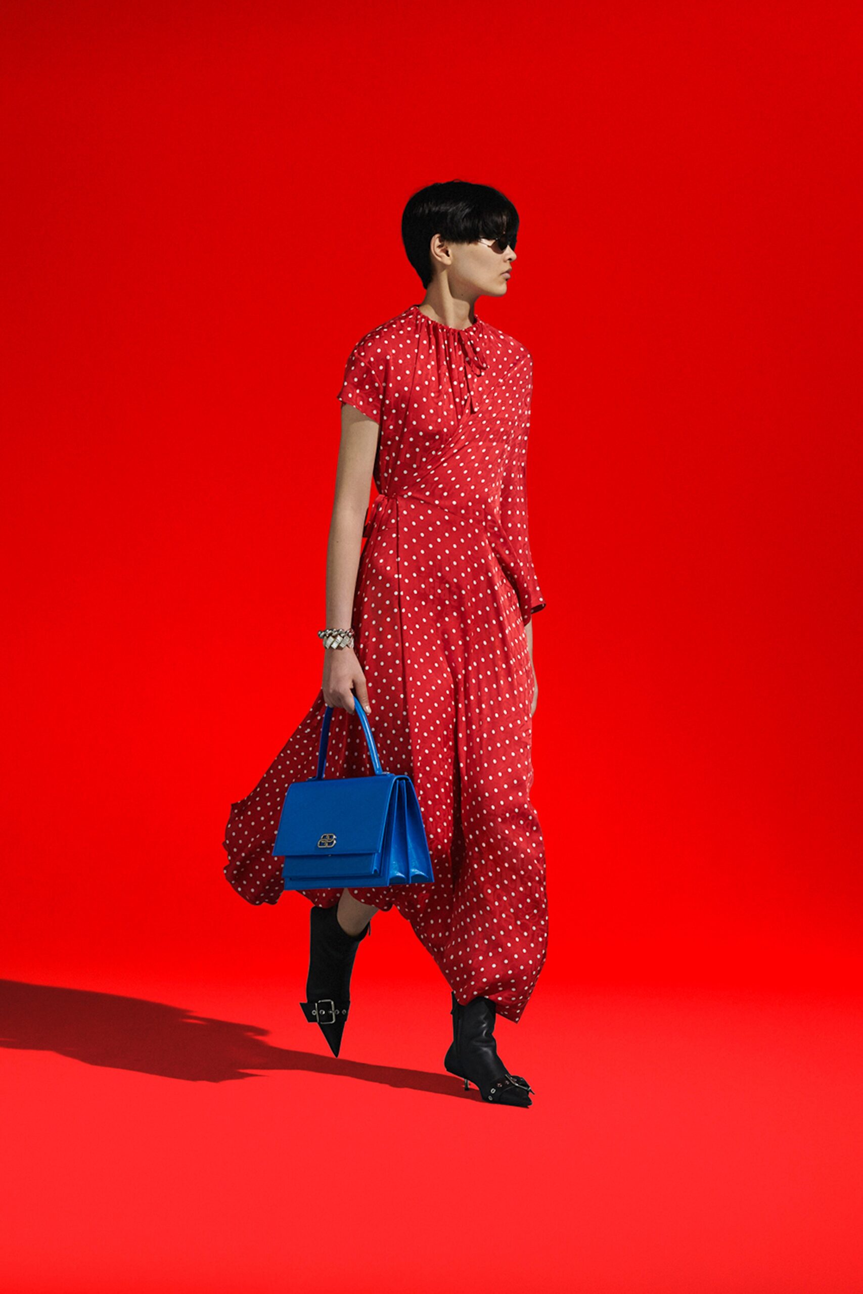 red polka-dot midi dress with blue bag