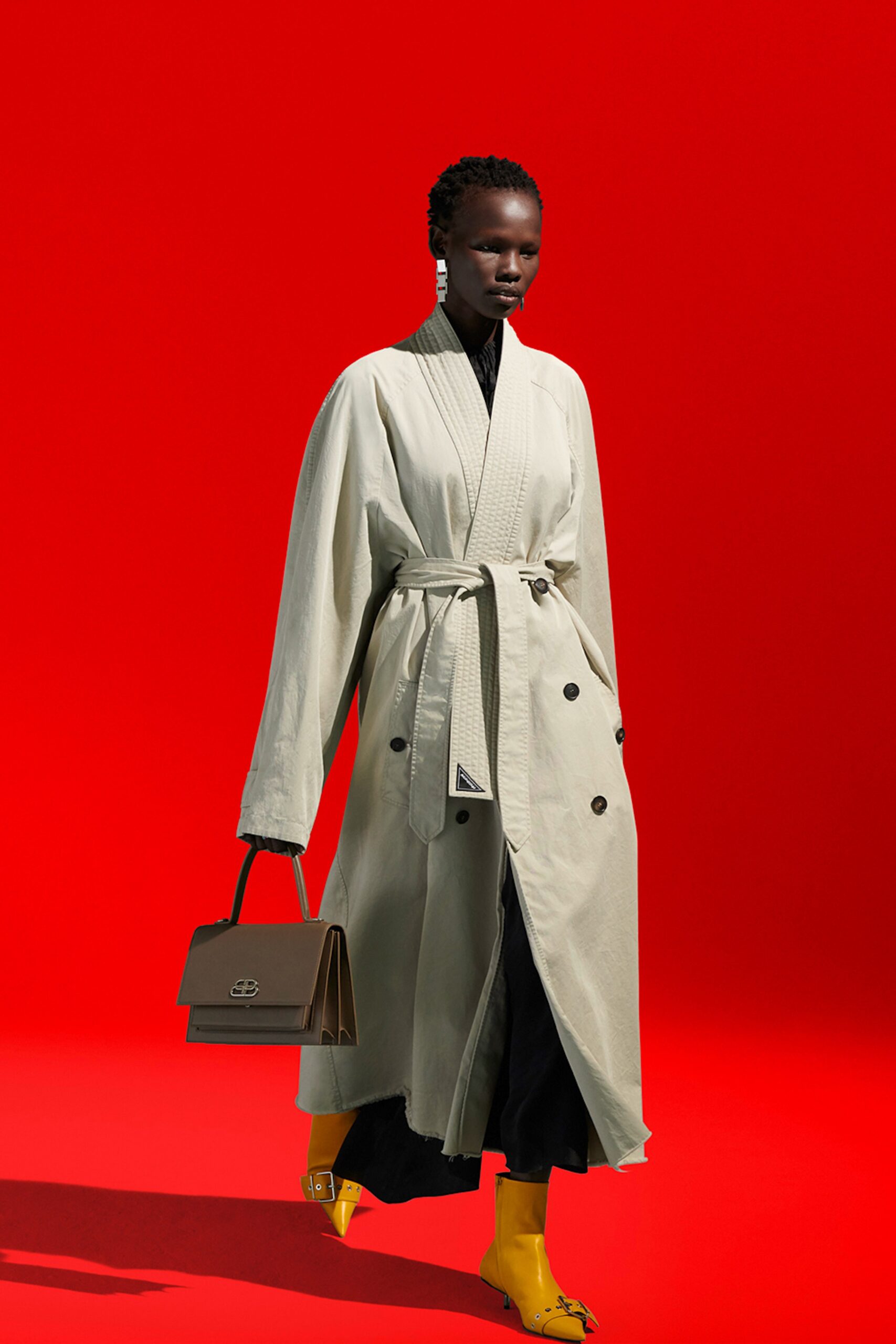 beige coat black pants yellow shoes