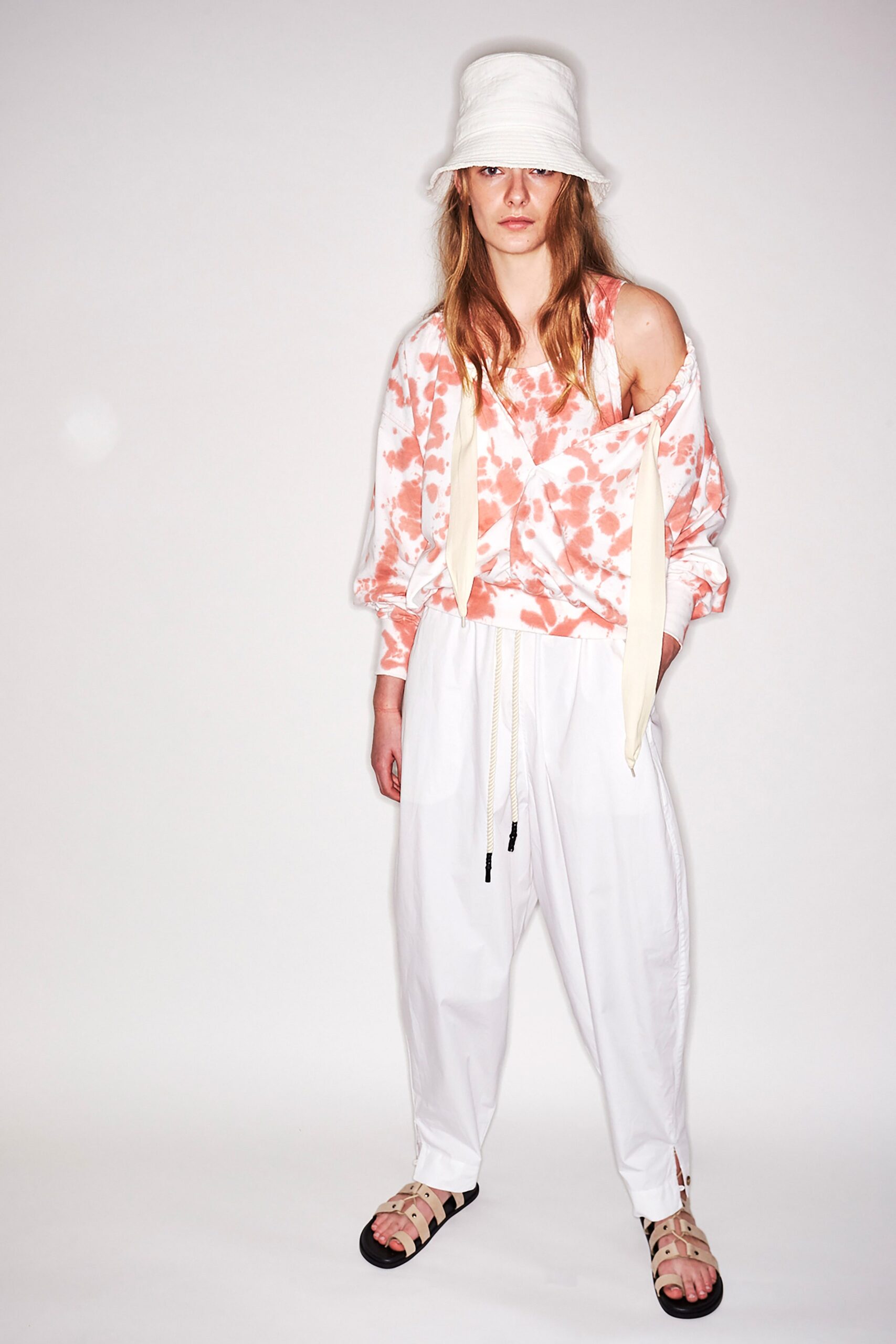 pink tie-dye relaxed sweater with white pants