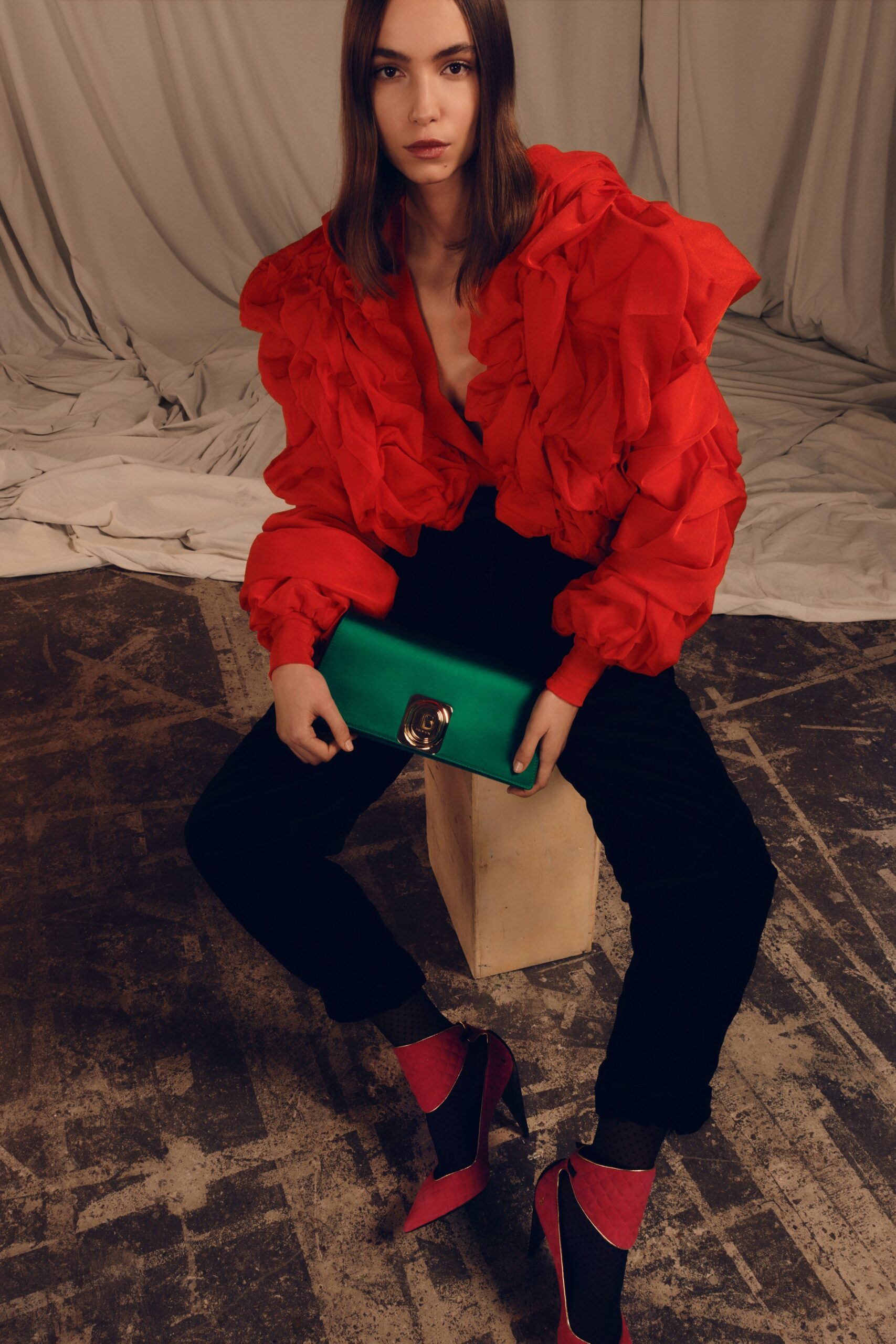 red ruffled top with black pants