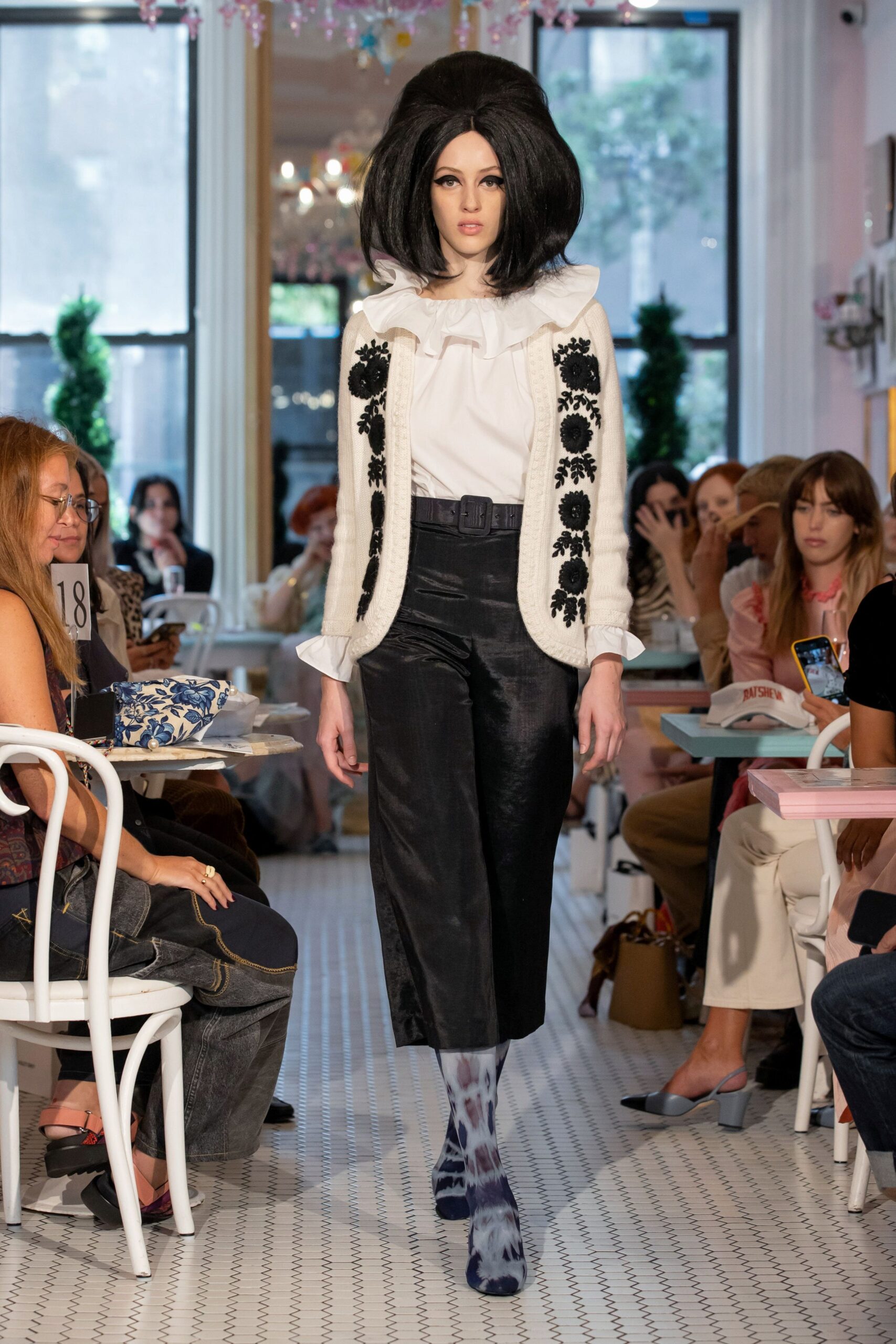 white ruffled blouse beige embroidered vest black relaxed pants