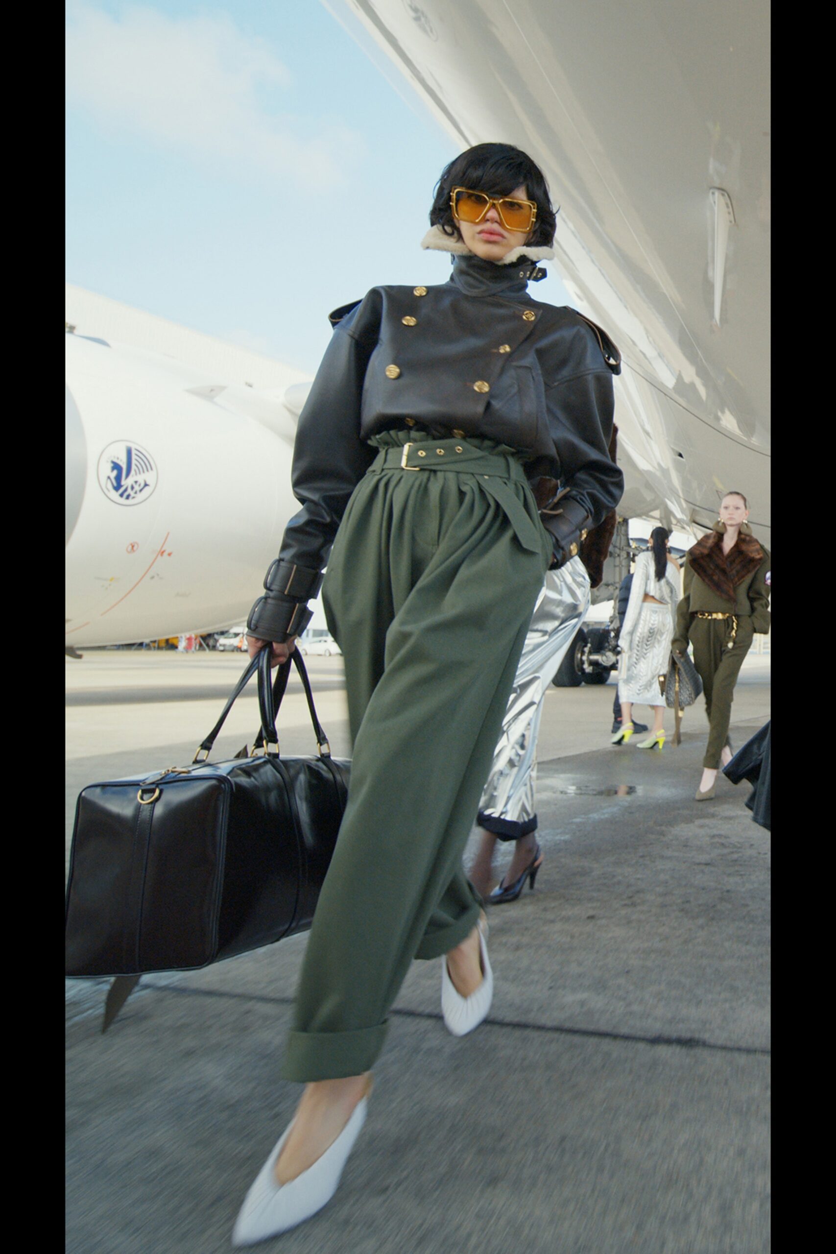 black leather fitted jacket with green pants