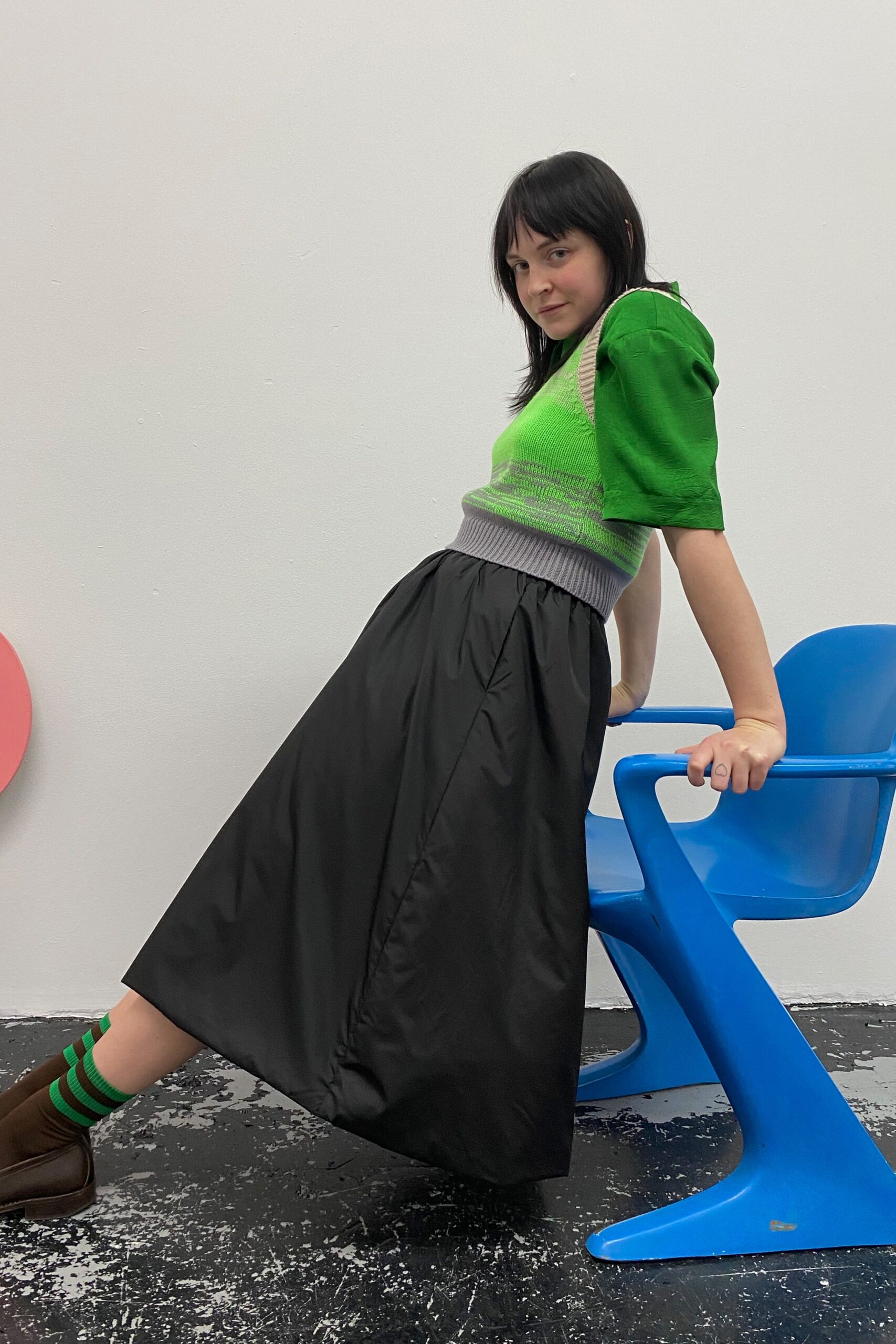 green fitted top and black midi skirt