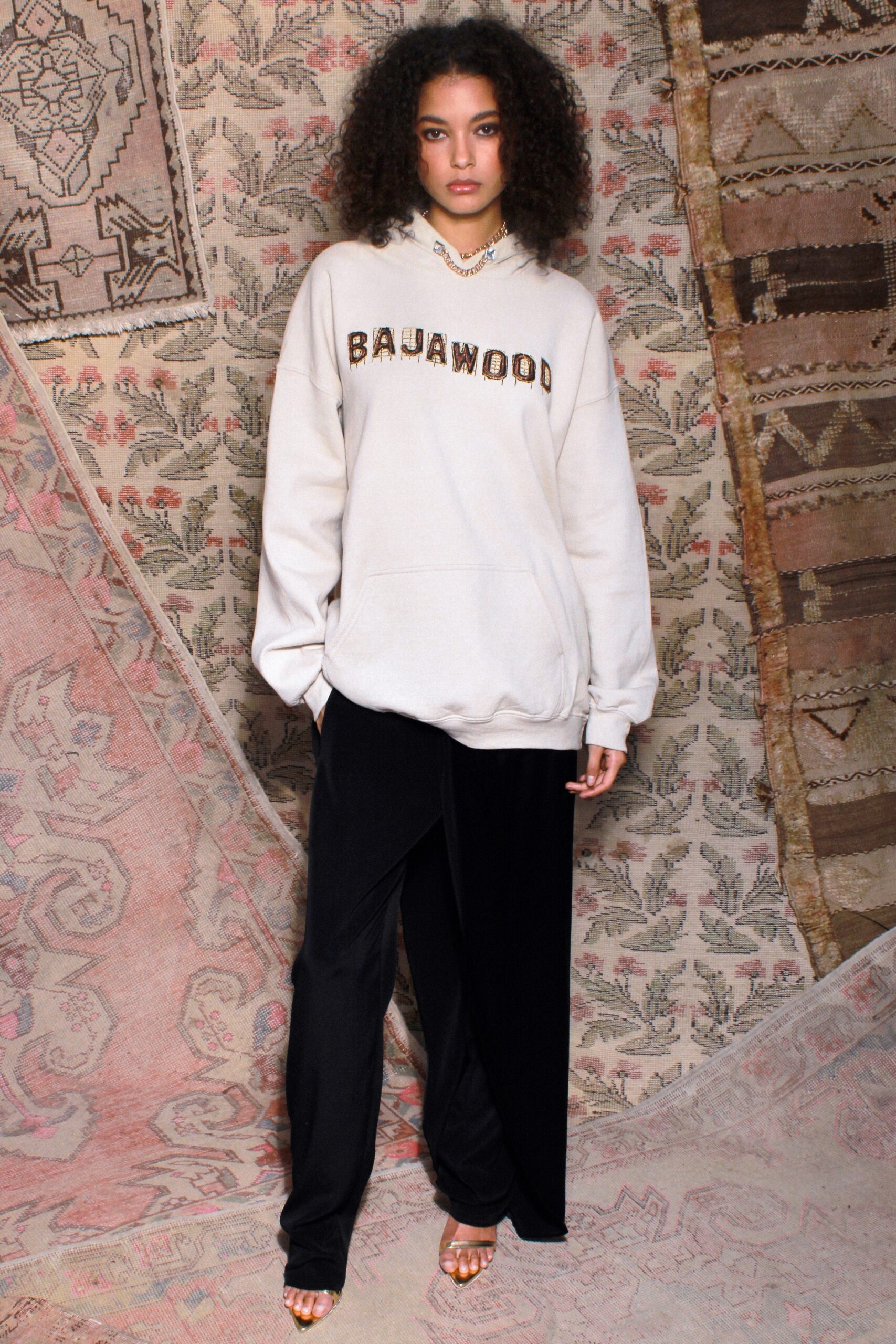 beige hoodie and black pants