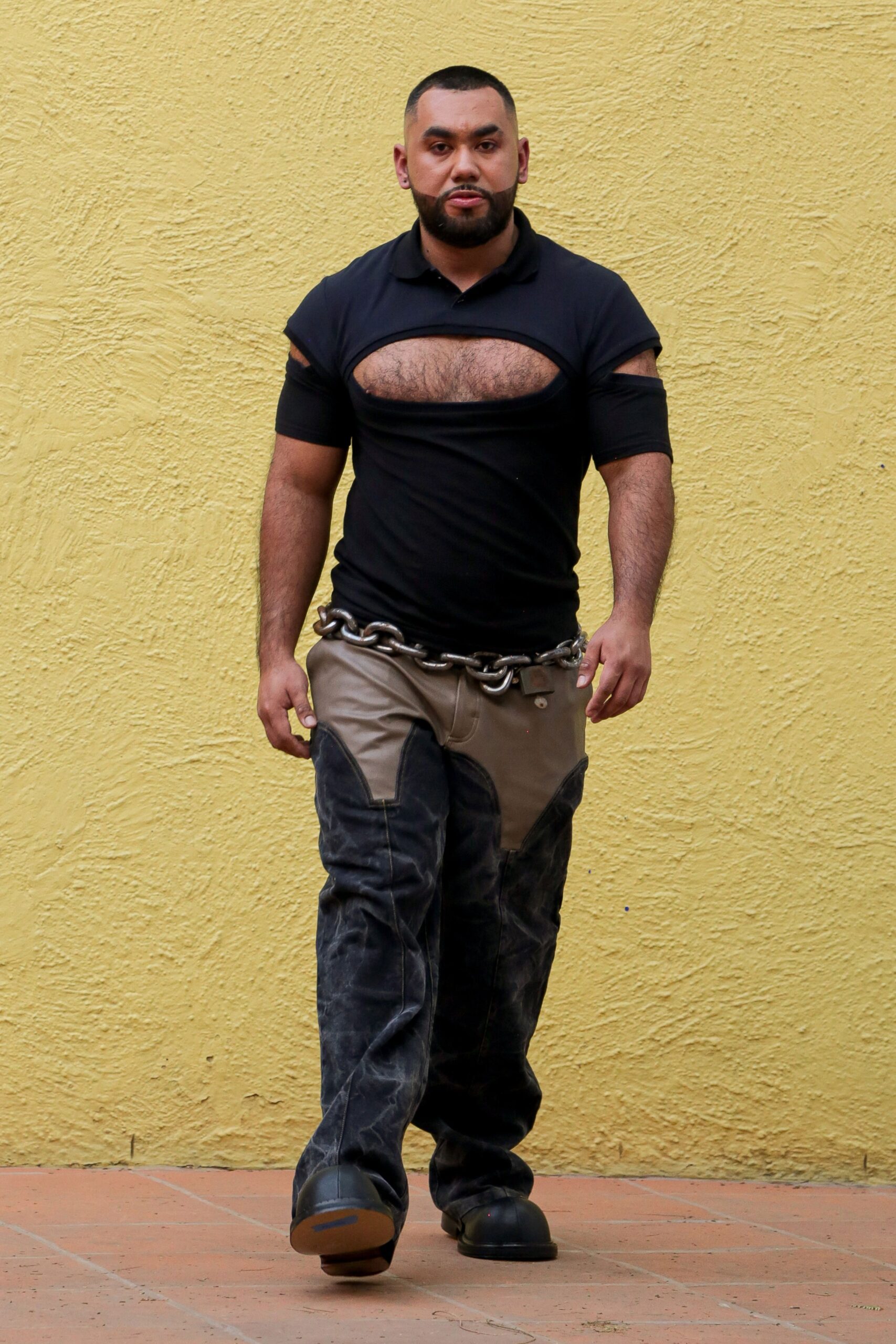 black cutout shirt and beige pants